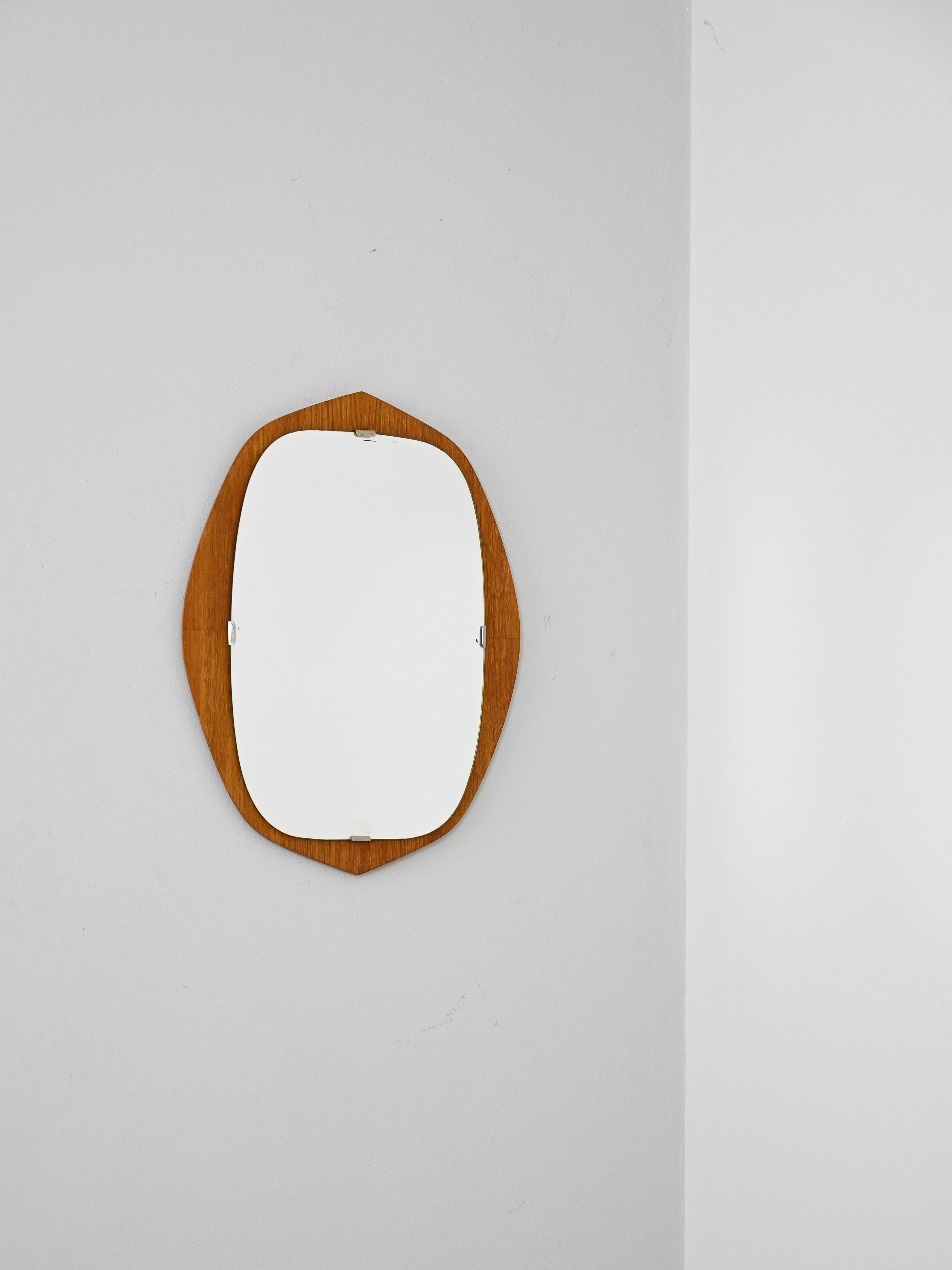 Petit miroir de fabrication scandinave des années 1950, avec cadre en bois de teck. Design compact aux lignes douces, typique du style nordique de l'époque.

Miroir scandinave fabriqué dans les années 1950, avec un cadre en bois de teck aux formes
