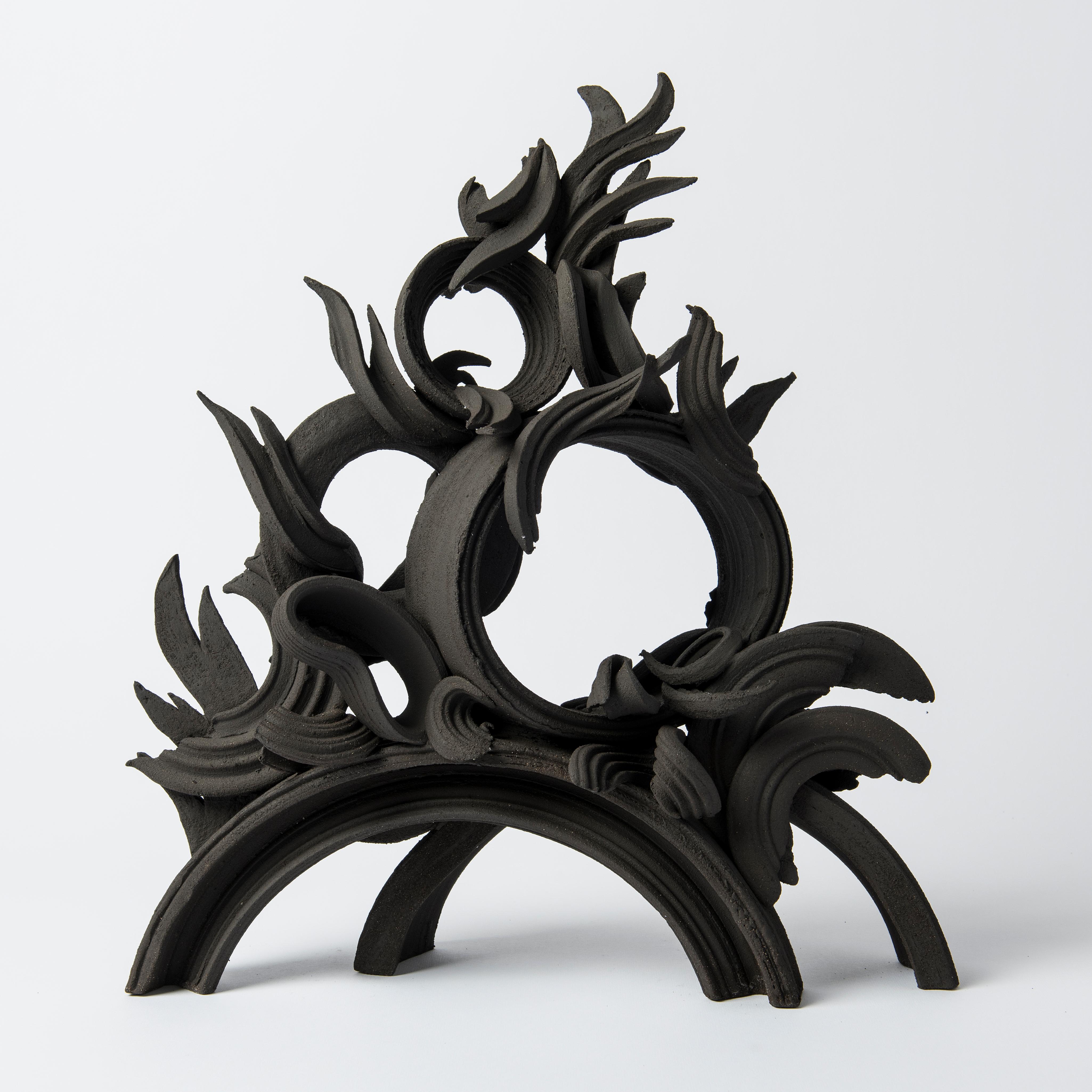 Piceous III is a unique handmade black stoneware ceramic sculpture by the British artist Jo Taylor. A completely hand-built artwork created from architectural-inspired flourishes and swirls. 

For Taylor, the making process hugely influences the