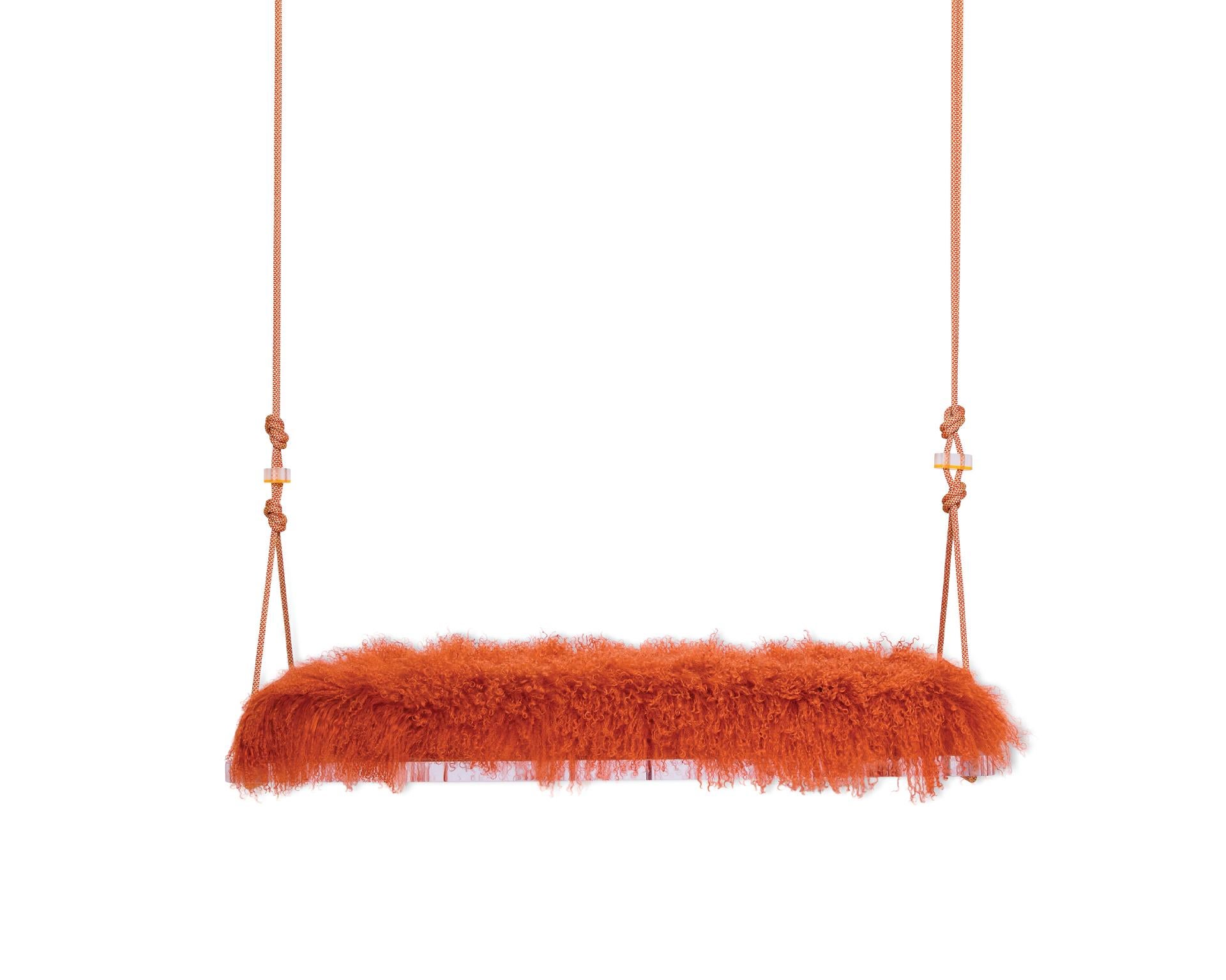 The Pick-Me-Up swinging bench is a playful indoor swing for two featuring a Tibetan Lamb cushion, colorful accessory cord, a Lucite base and Lucite accessories. Featured here is a 1970s inspired Orange, however, there are a variety of Tibetan Lamb