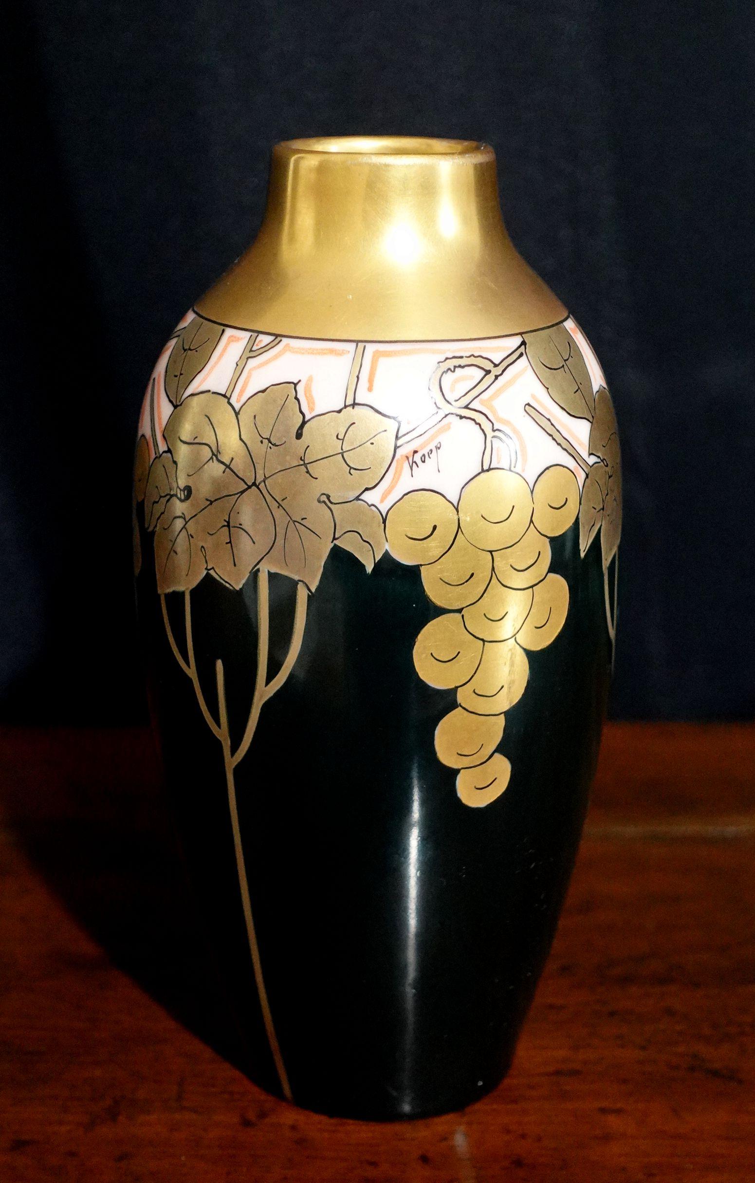 Art Nouveau Pickard hand-painted porcelain vase having a gold grape cluster and leaves design with black ground signed Koep. Stamped mark to bottom. Measures approx. 7