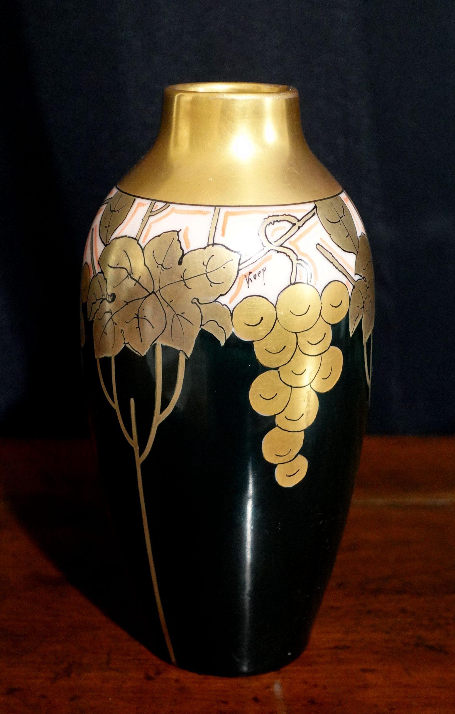 Vaso in porcellana Art Nouveau Pickard dipinto a mano con disegno di grappolo d'uva e foglie in oro e fondo nero firmato Koep. Marchio timbrato in basso. Misura circa 7