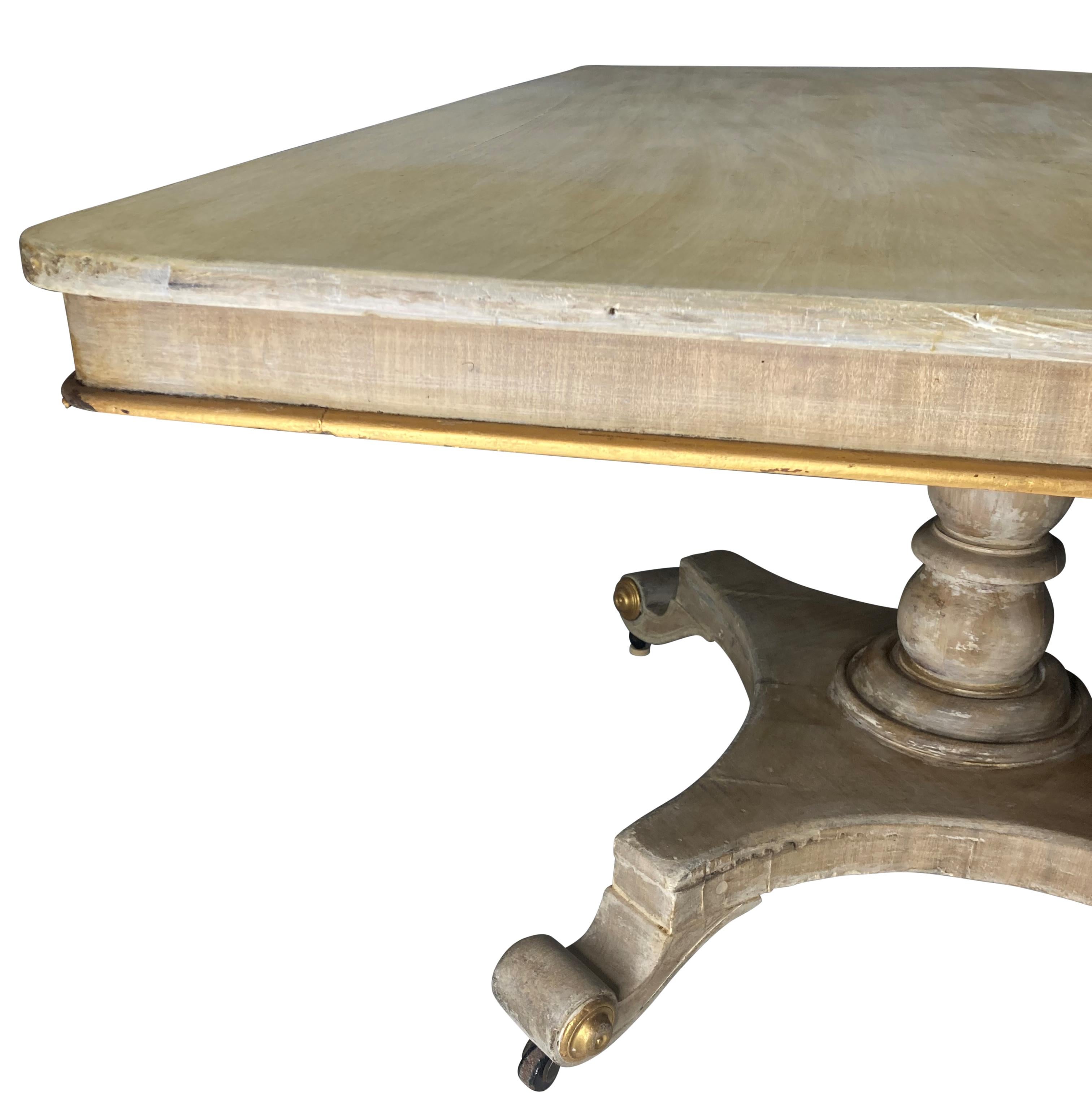 A pickled mahogany, English Regency breakfast table, with some parcel gilding.