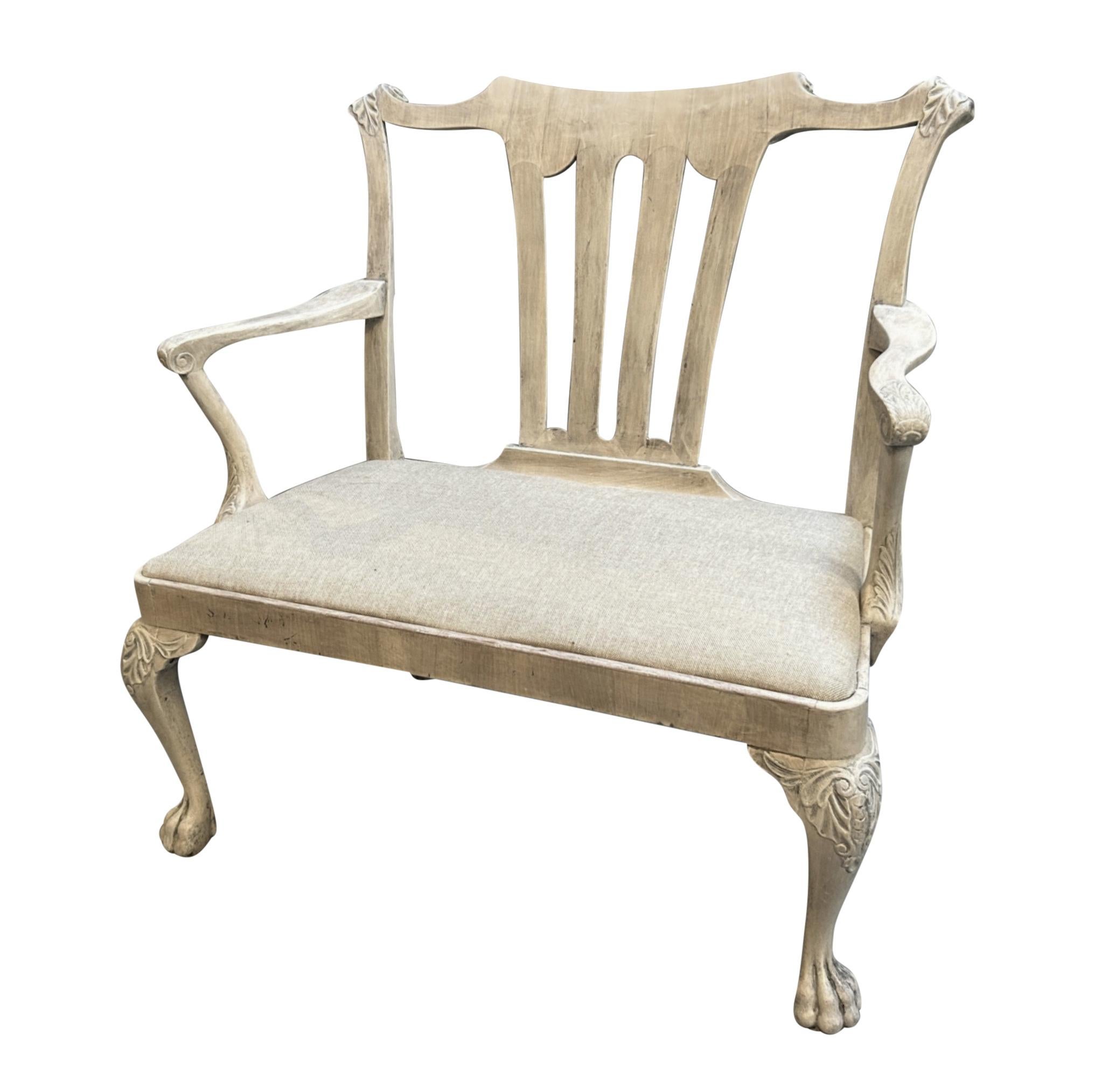 An English Georgian style, pickled mahogany settee in the manner of Syrie Maugham. With a plain linen seat, on cabriole legs with claw feet.