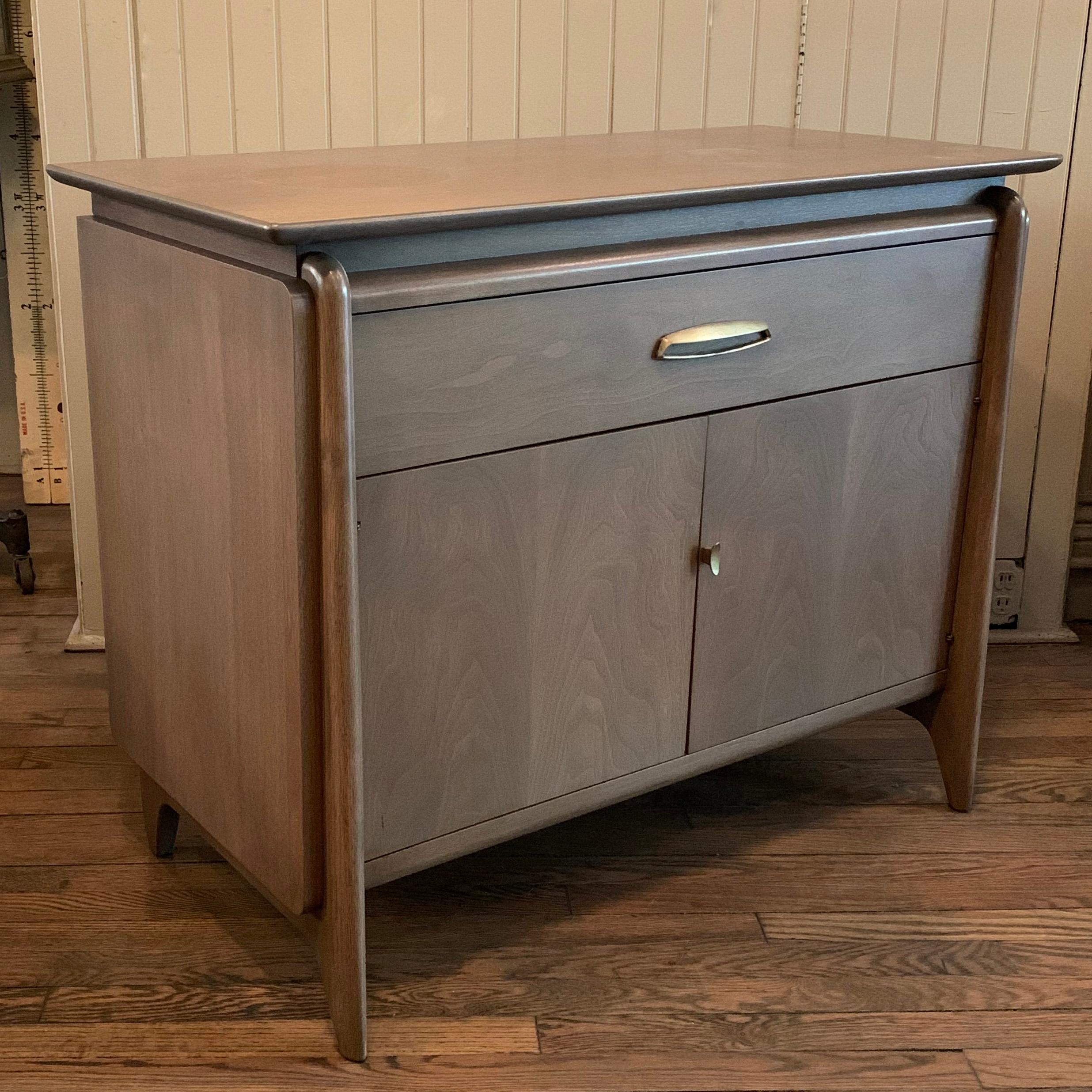 Wonderfully detailed, Mid-Century Modern, pickled mahogany, sideboard cabinet by John Van Koert for Drexel features cabinet space below with 14 inch interior height and a fixed shelf and top drawer with brass pulls.