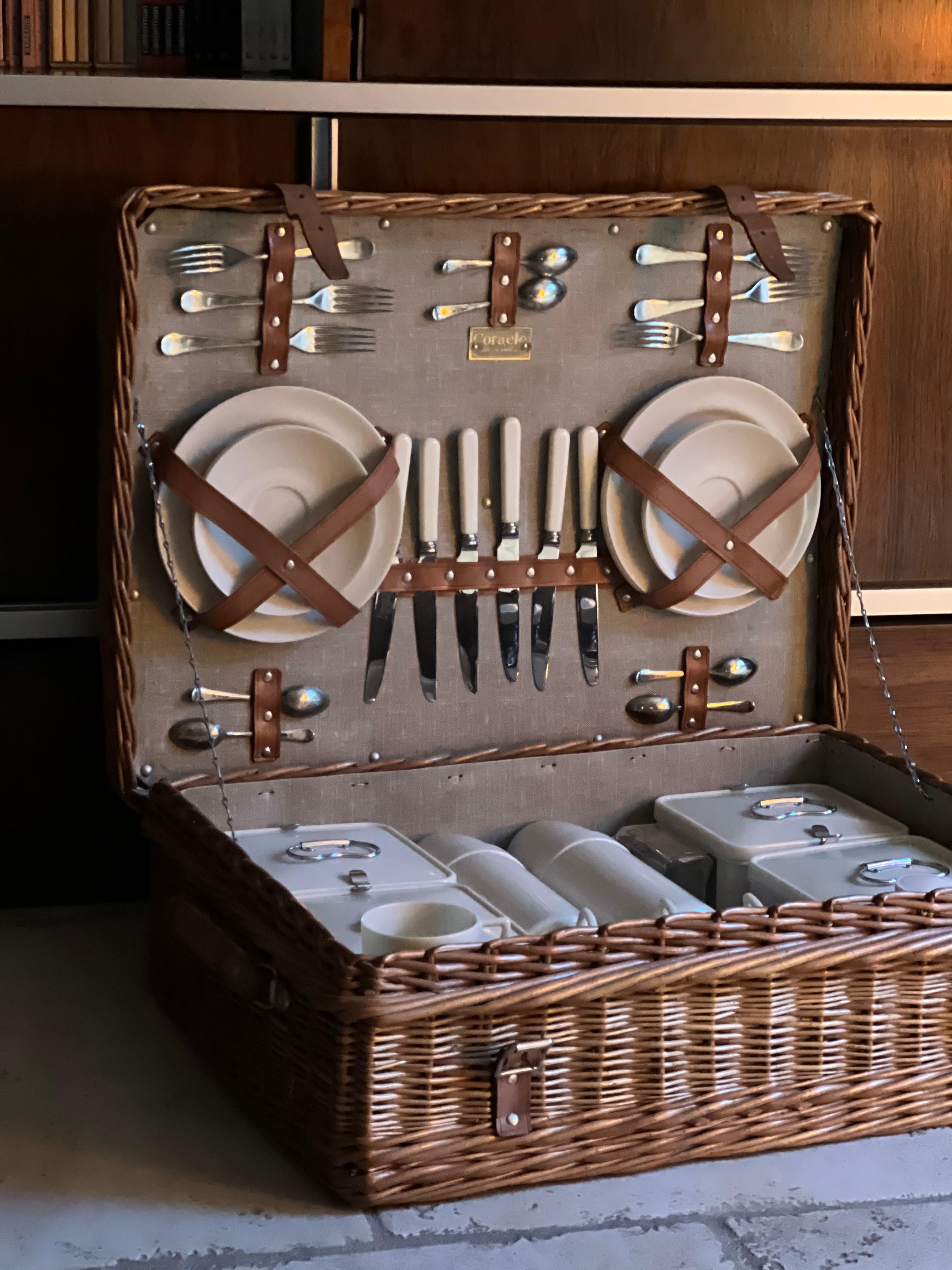 Picnic basket for 6 people Coracle by G. W. Scott and Son Circa 1930 in wicker with handles, lock and clasp in brass, the lid opening on an interior lined with canvas with wicker carcass, containing:
3 Thermos
4 Boxes
Cutlery for 6 people (silver
