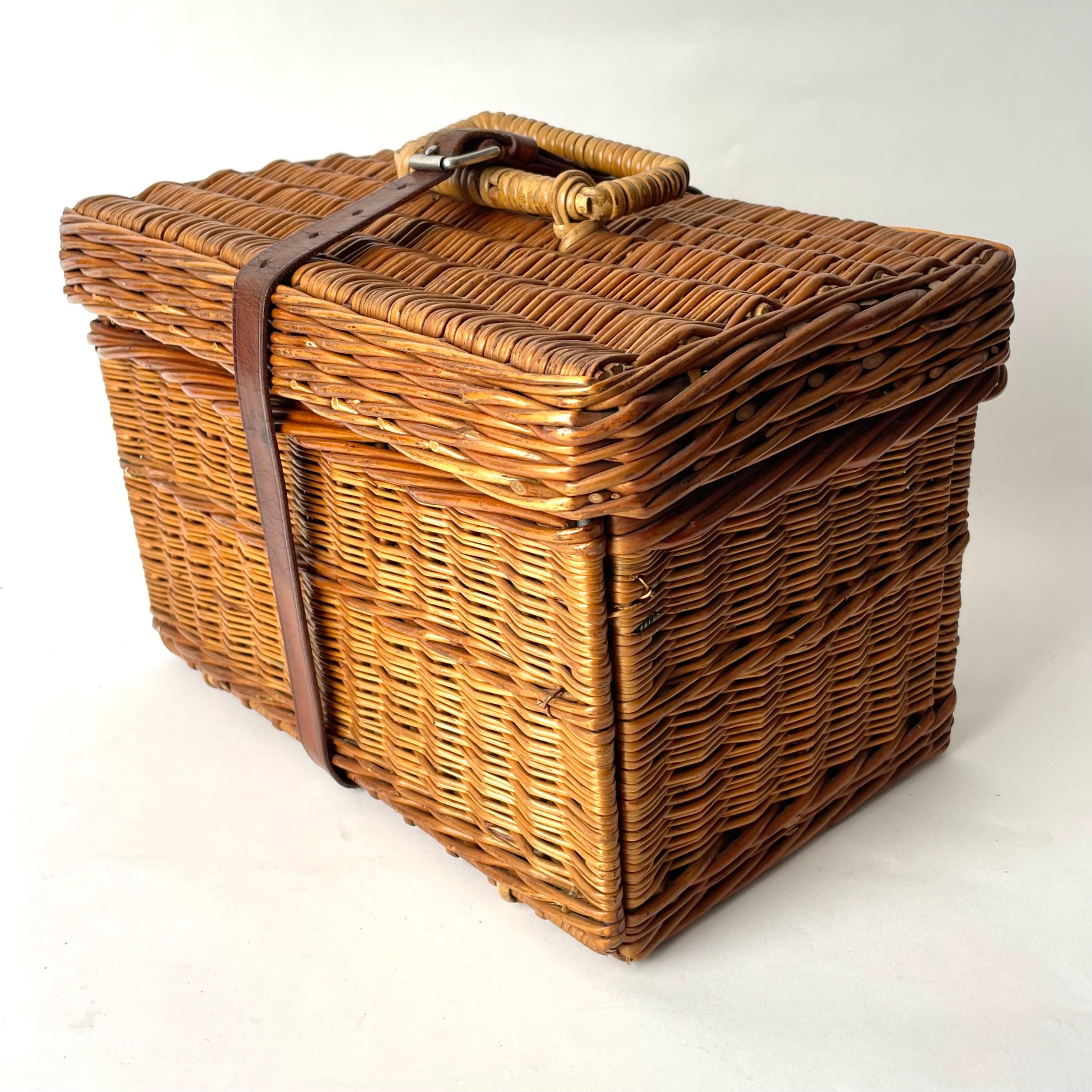 A late 19th Century/early 20th Century Picnic Basket in Rattan complete with interior pieces in Tinplate and Porcelain. Manufactured in London. Provenance, from the Swedish noble family Stjernswärd.

This charming and functional rattan picnic basket