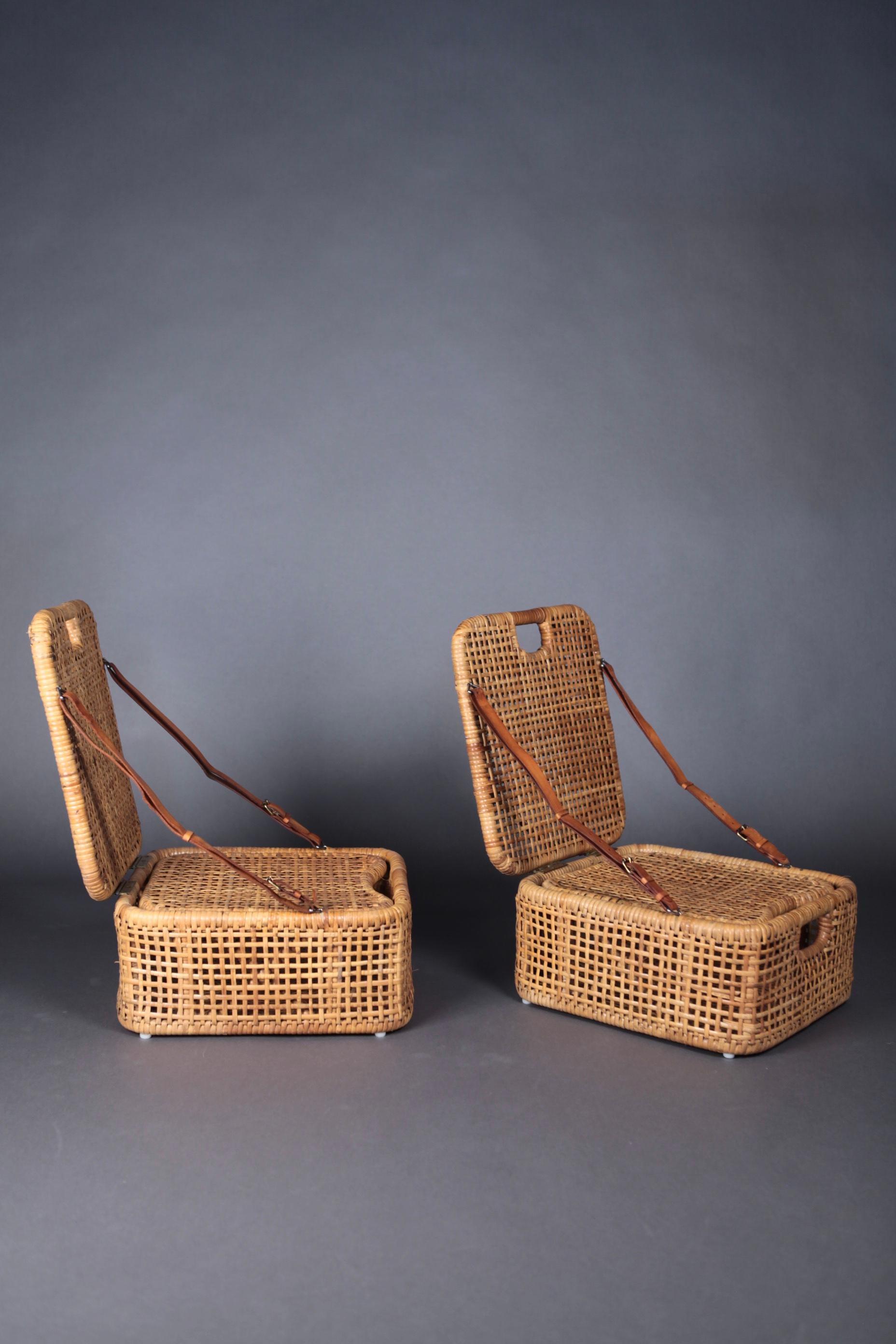 A pair of woven cane and natural leather picnic chairs and baskets.
In great vintage condition, manufactured in Sweden in the 1950s.
The box consists of an inlayed seat, with storage and transport space.
The backrest is held by 2 original leather