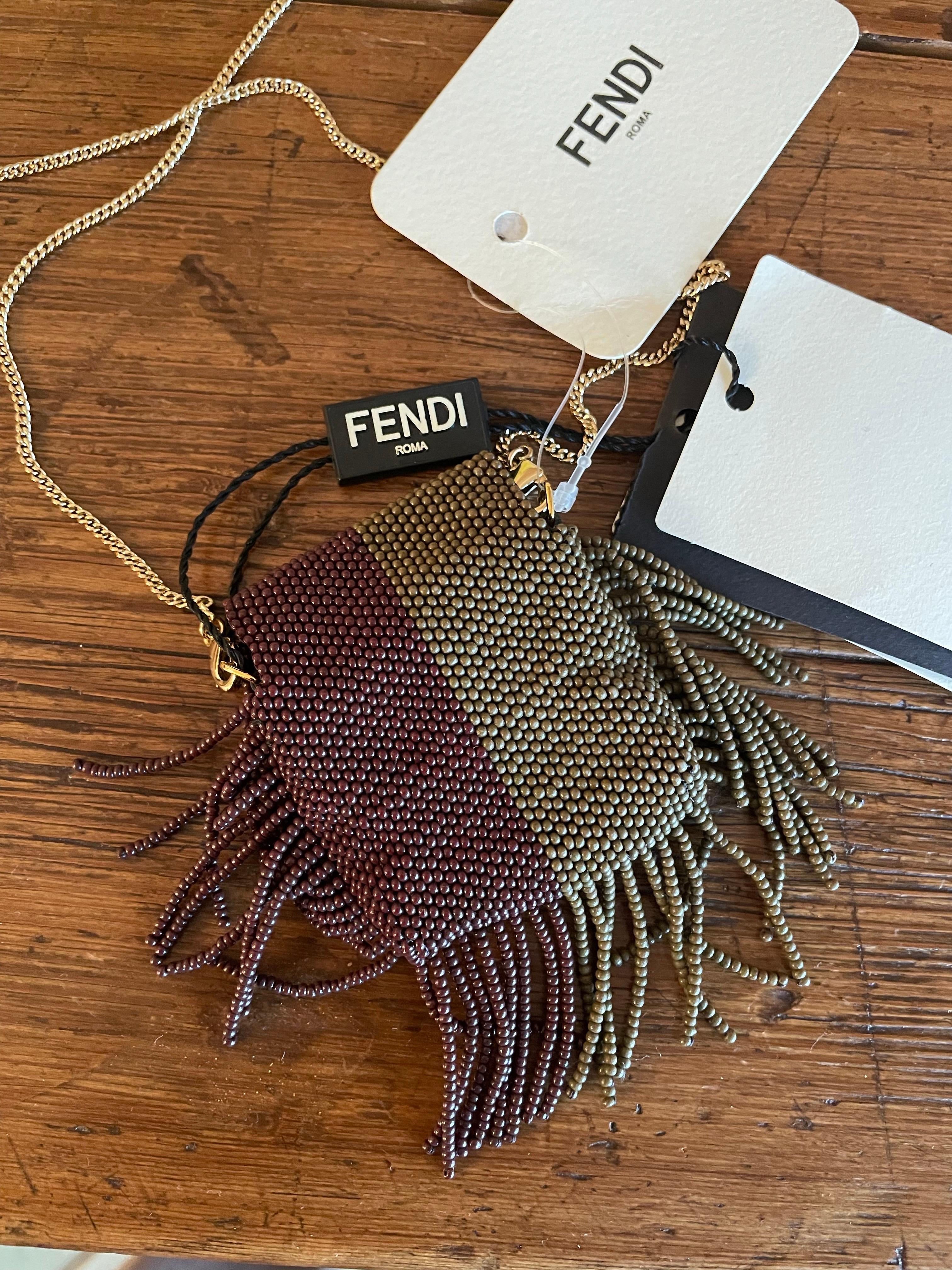 Pico Baguette with two-tone tobacco brown beads and dark brown embroidery with fringes. Golden metal clip button closure with classic logo. Soft, it measures 5 x 6 cm.
Removable fine gold metal shoulder strap. Shoulder strap measures 60 cm.
New with