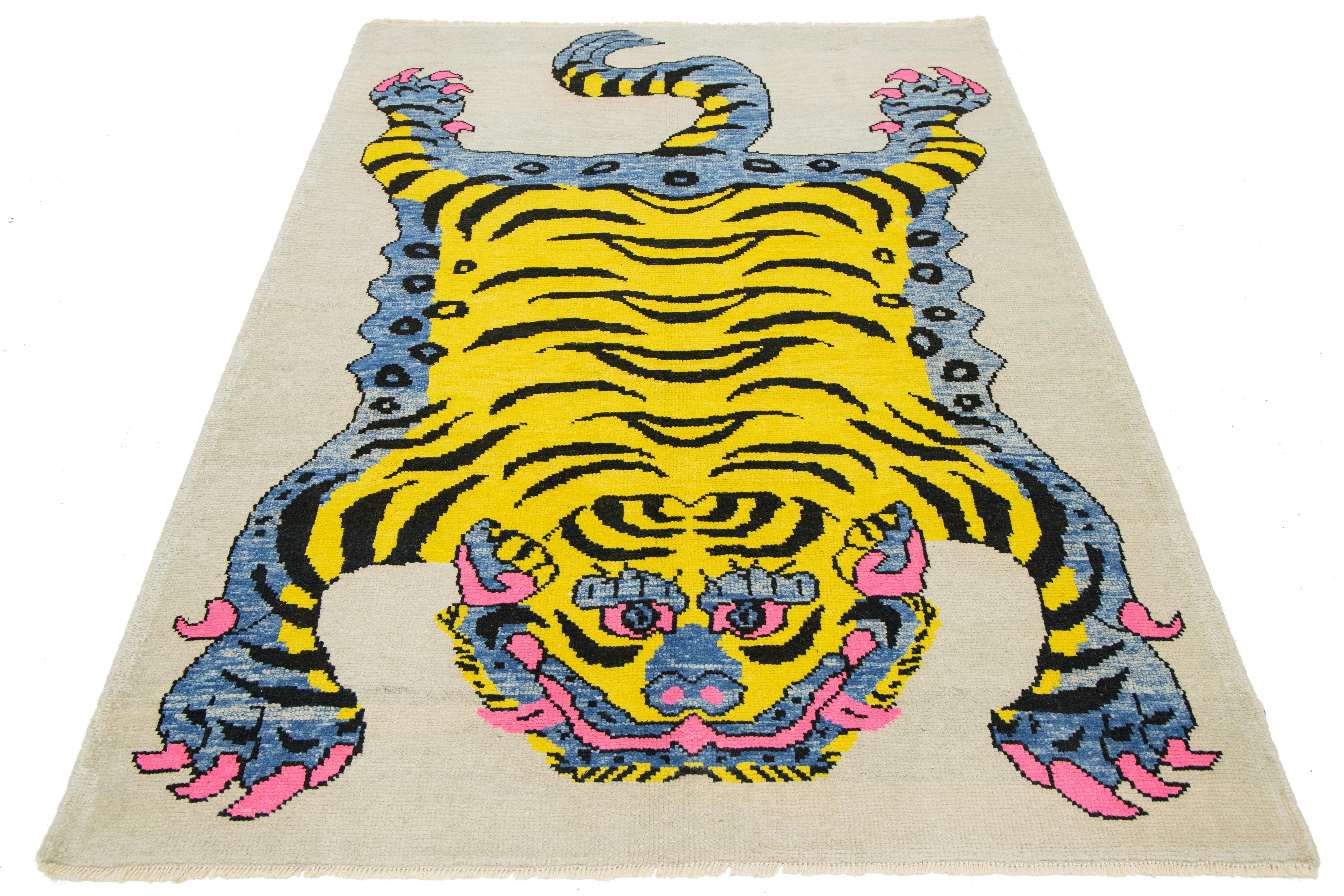 Esta alfombra turca de lana Art Decó presenta un llamativo fondo beige con detalles en negro, amarillo, gris y rosa, y una cautivadora representación pictórica de un tigre.

Esta alfombra mide 1,70 x 1,80 m. 

