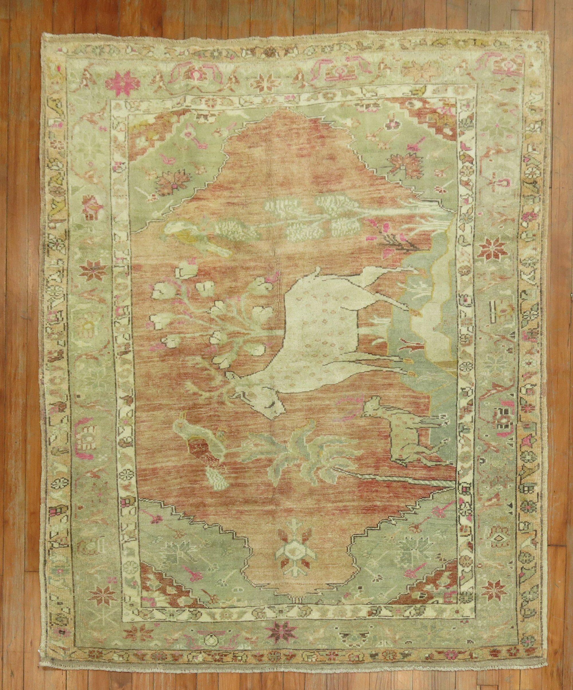 Einzigartiger handgeknüpfter türkisch-anatolischer Teppich in blassem Pfirsich, braunen und grünen Akzenten, der einen großen Hirsch, eine kleine Ziege und ein paar Vögel zeigt

Maße: 4'6