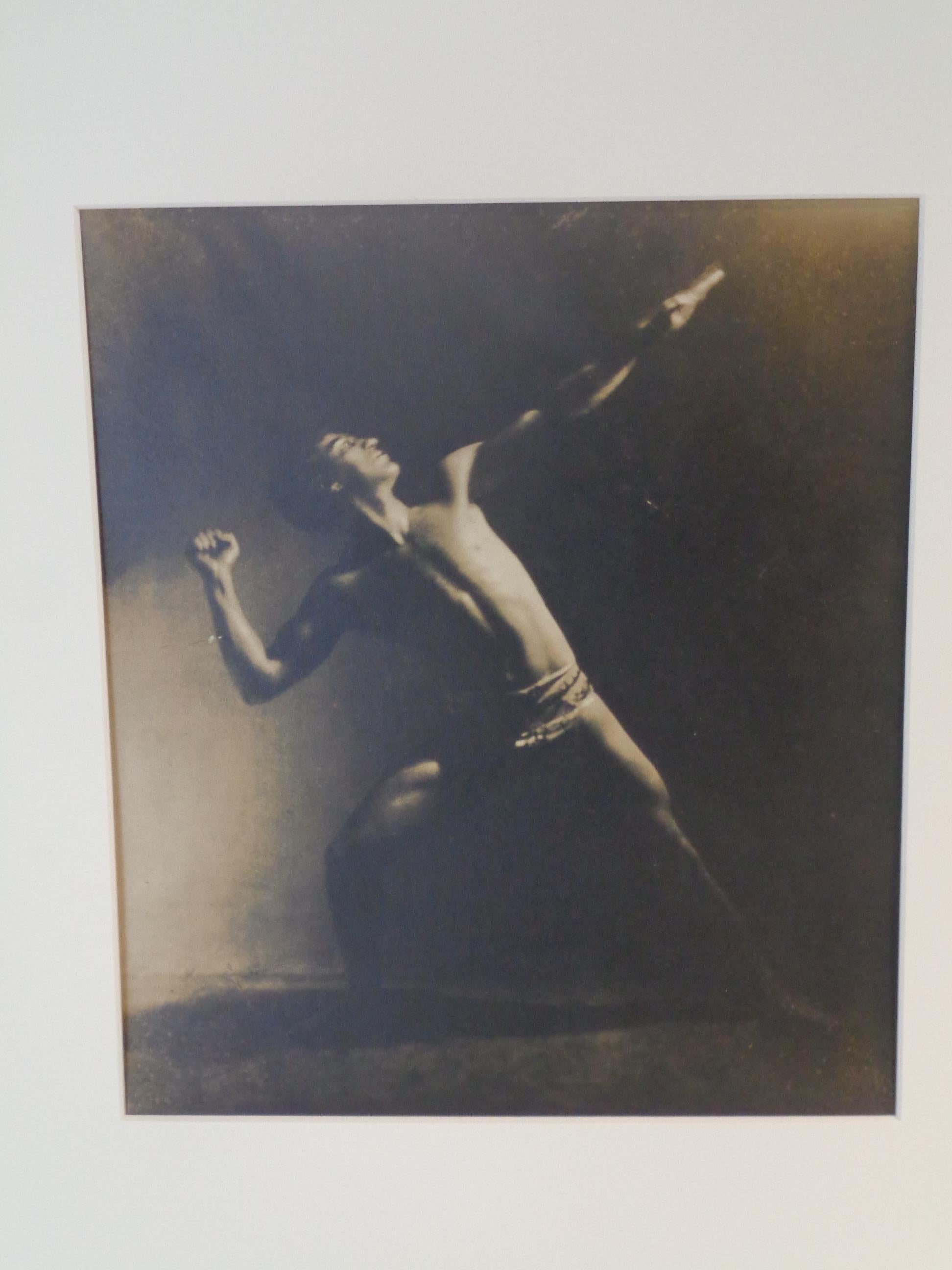 Original early pictorialist sepia tone gelatin silver print photograph of a theatrically posed partially clad muscular male nude by Rochester NY photographer Ned Hungerford. Circa 1900-1910. Mat size 20