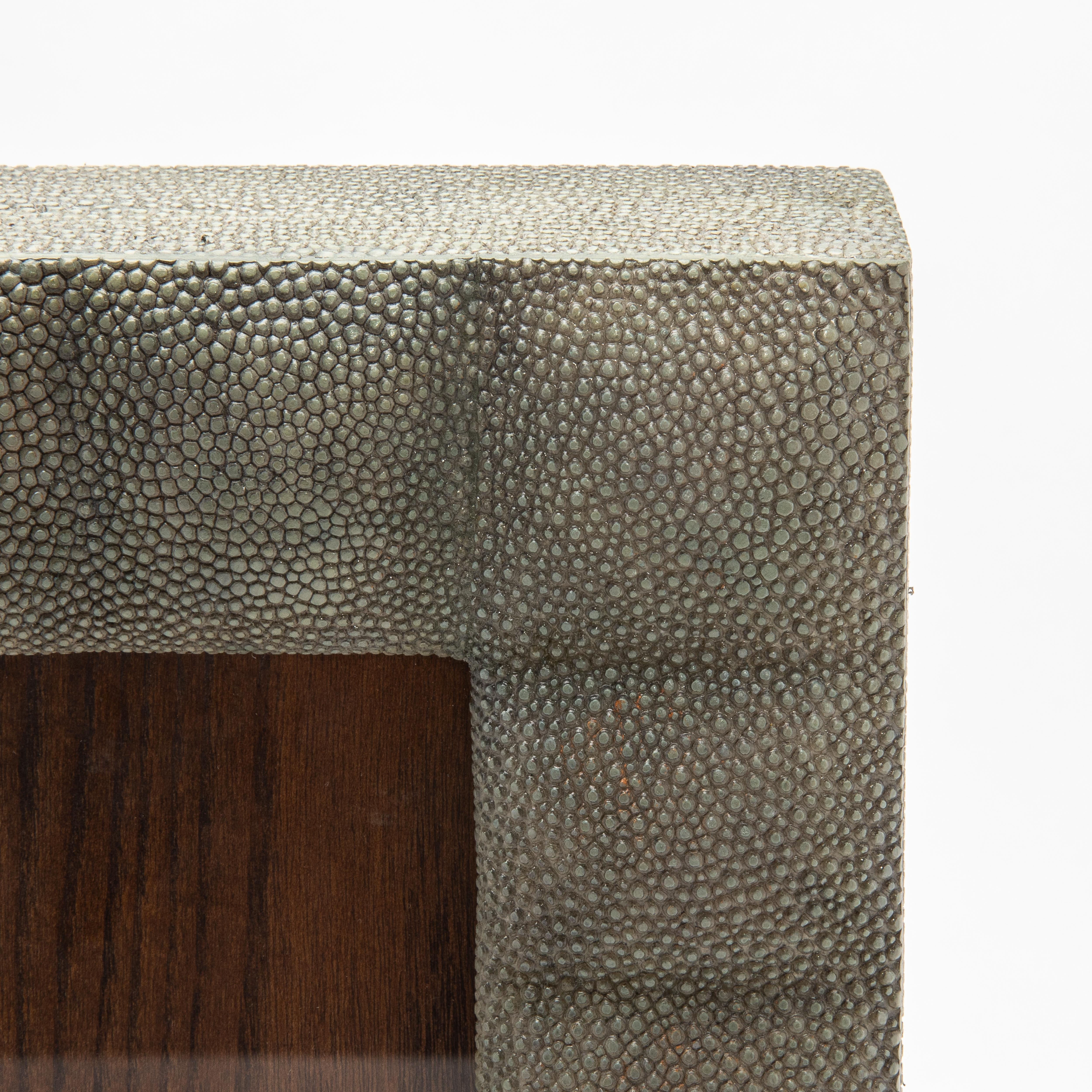 Este lujoso marco de R & Y Augousti está fabricado en su característico acolchado de piel de zapa gris, que destila elegancia atemporal y refinamiento moderno. La textura táctil del acabado shagreen contrasta maravillosamente con la ventana de