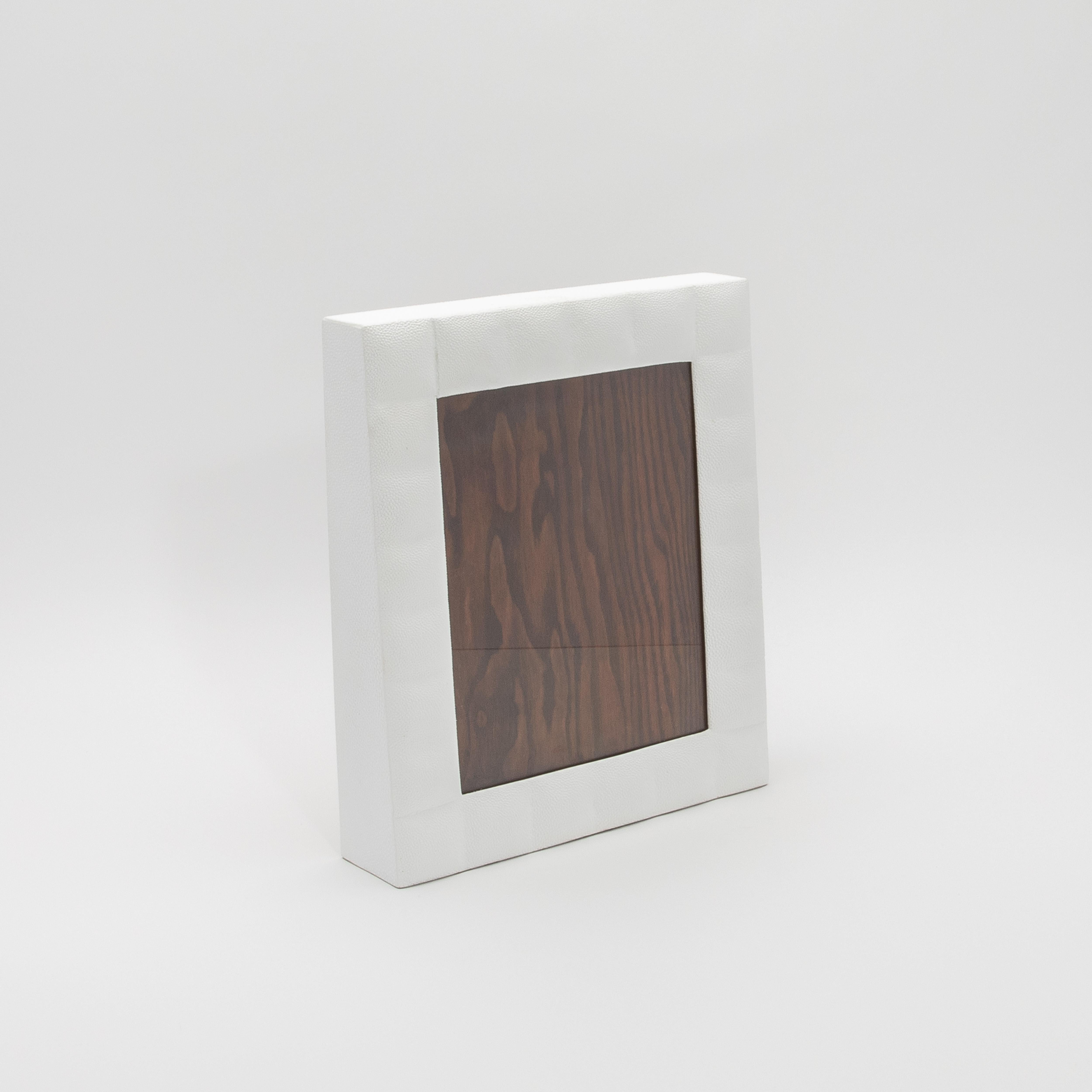 Este lujoso marco de R & Y Augousti está fabricado en su característico acolchado de piel de zapa blanca, que destila elegancia atemporal y refinamiento moderno. La textura táctil del acabado shagreen contrasta maravillosamente con la ventana de
