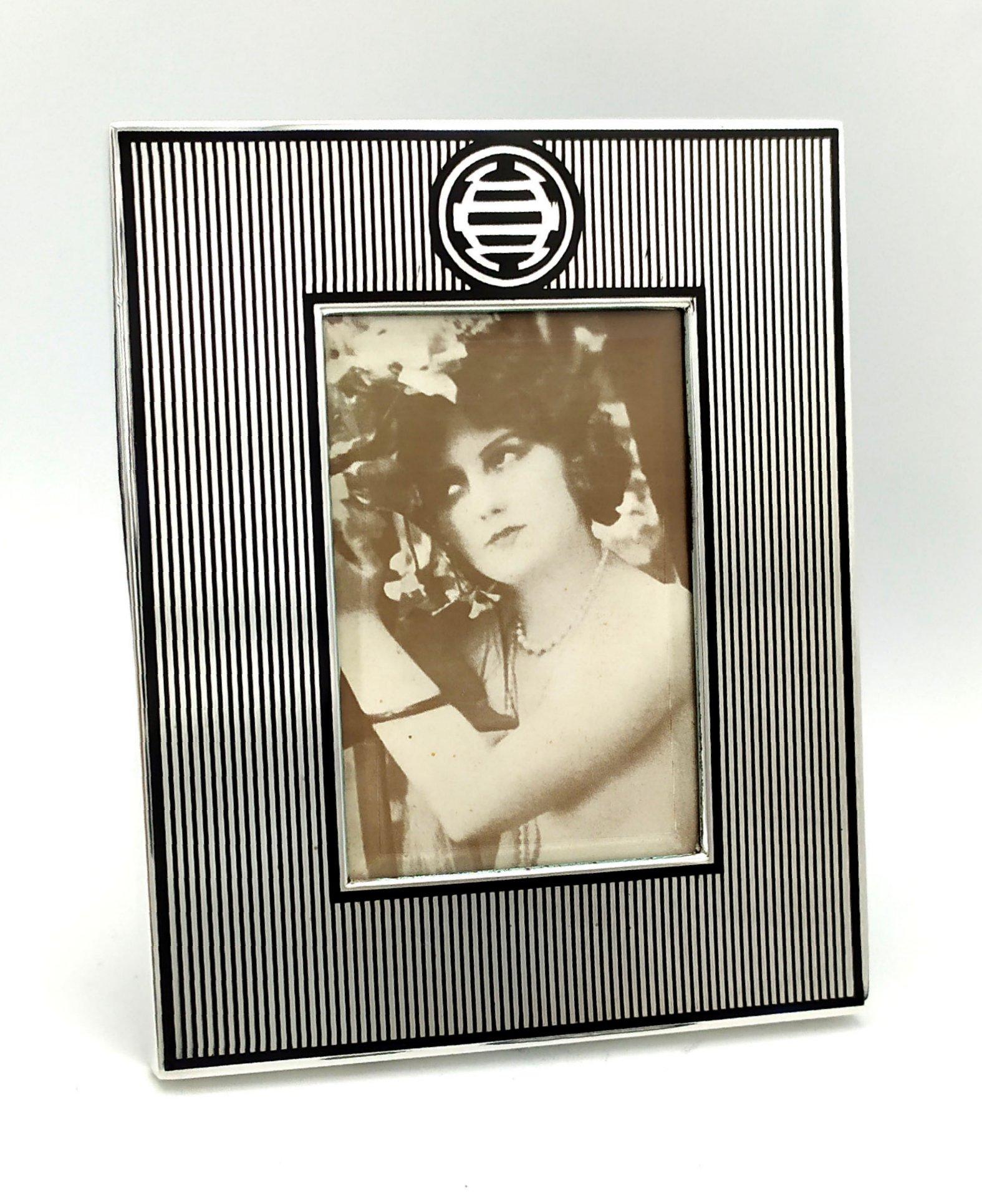 
Rectangular photo frame in 925/1000 silver with geometric design and fire-enameled with Chinese influence style. External cm. Internal 11.6 x 14.6 cm. 6 x 9. Weight gr. 194. Created in Art Deco style for Cartier USA in the 1980s, inspired by