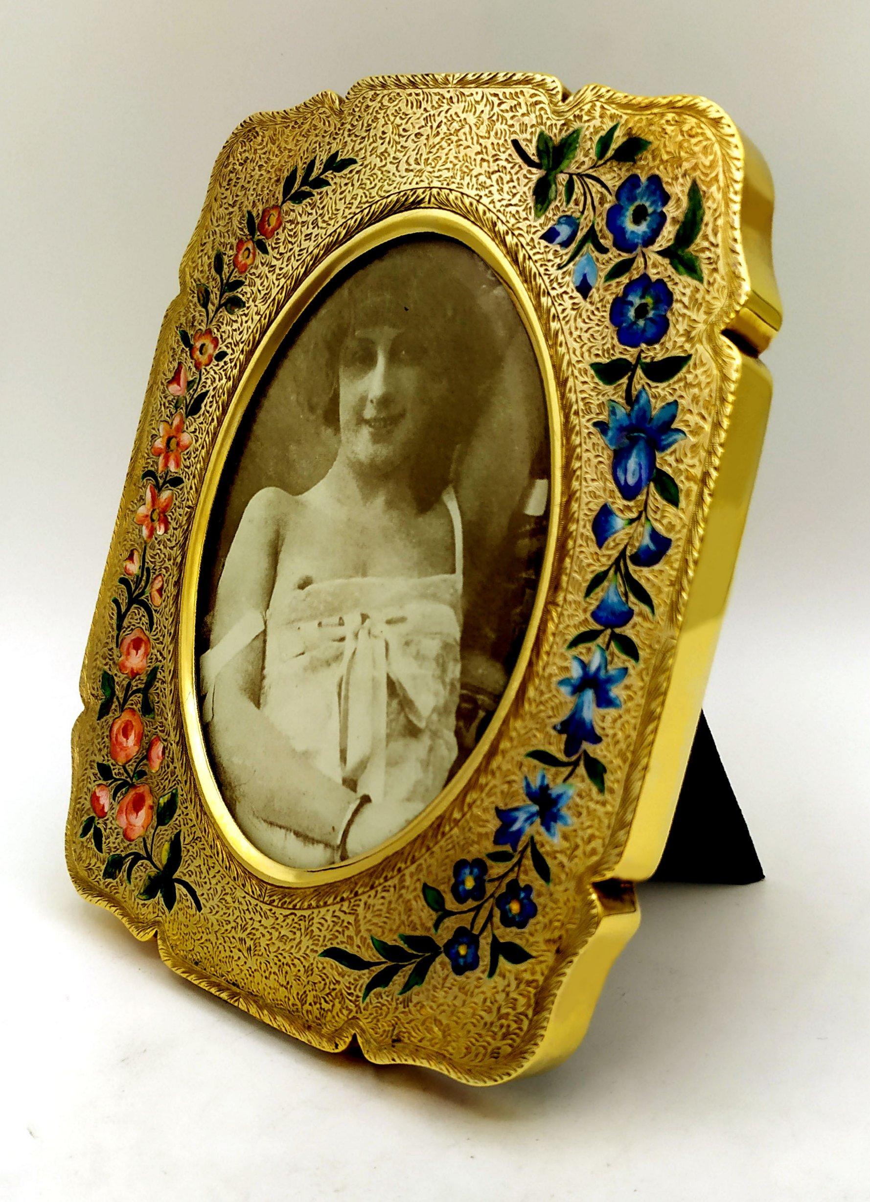 Rectangular shaped frame for oval photos cm. 7.8 x 10.4 in 925/1000 sterling silver gold plated with very fine fire-enameled floral engraving and hand-painted by the painter Renato Dainelli, in Art Nouveau style, early 1900s. External measurements