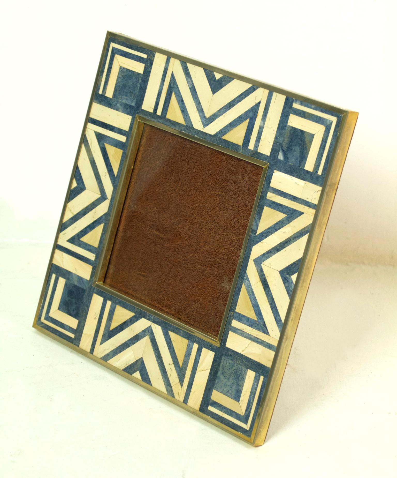 A large square Art Deco style photo/picture frame with a graphic pattern in blue and ivory colored marble with brass surrounds. Considering it is marble it´s carries some weight to it.