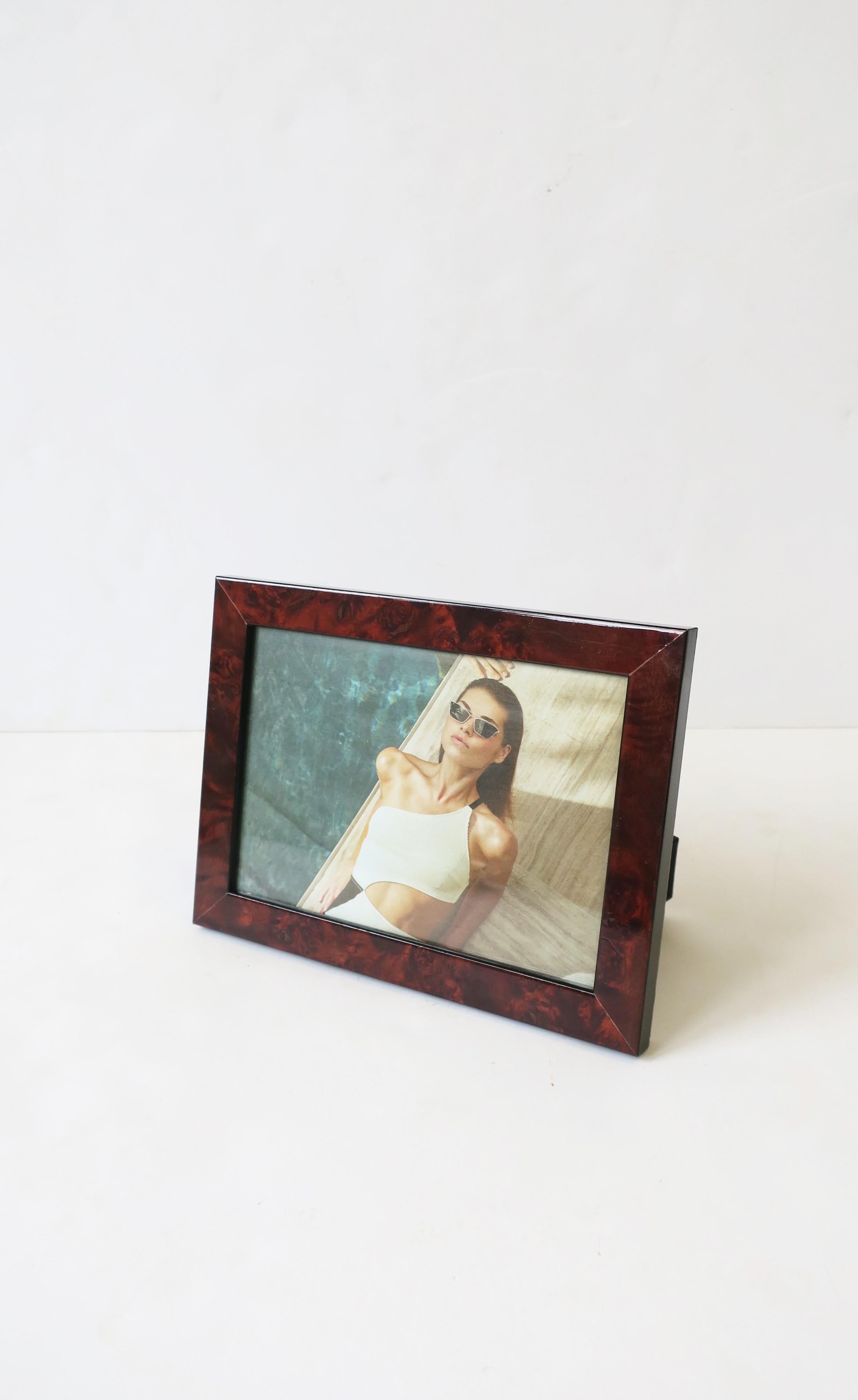 A beautiful picture frame in burl wood and a dark blue shagreen-esque embossed back, finished with brass hardware. Frame can sit both horizontal or vertical as demonstrated in images. Frame measures: 6.25