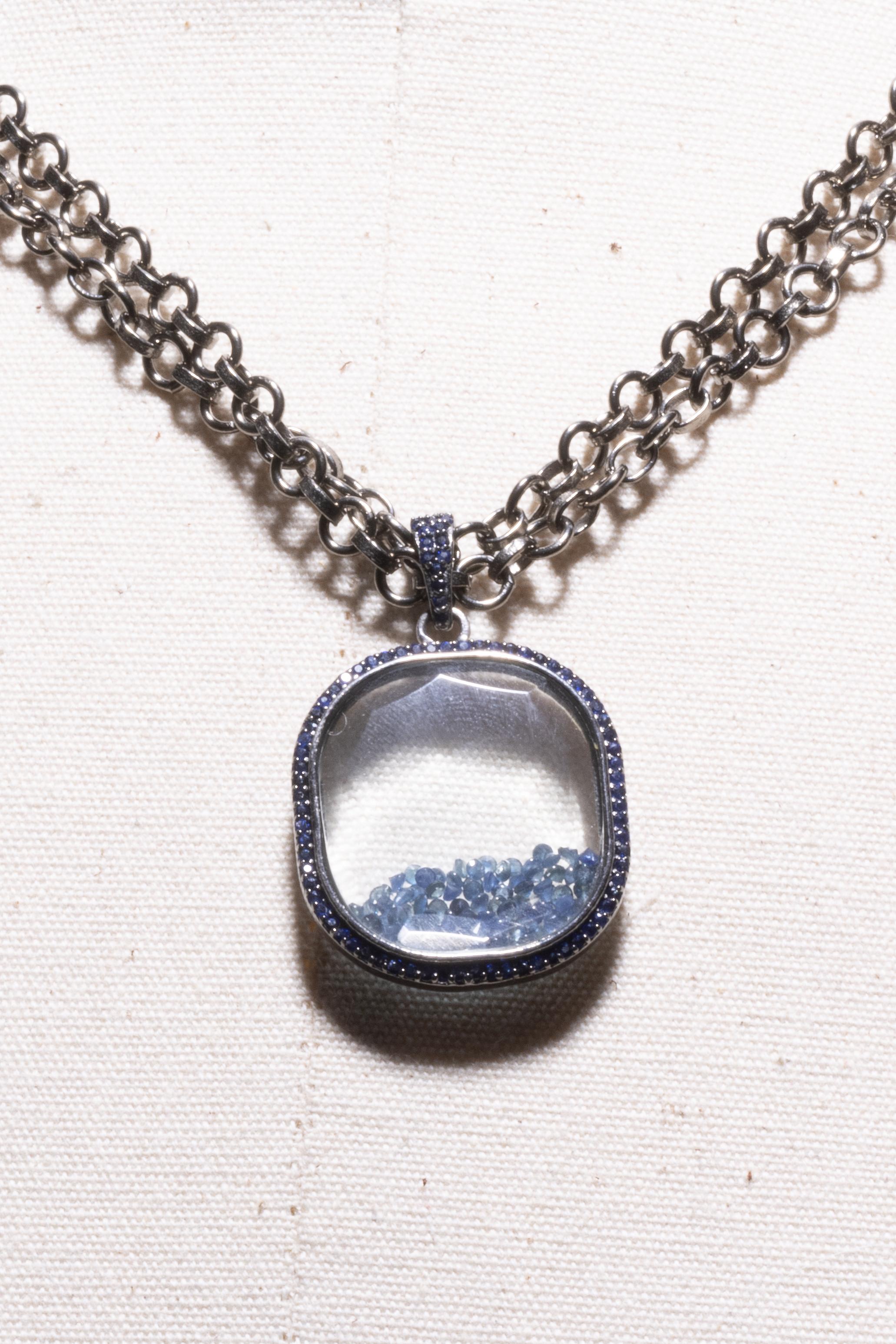 To be worn long or short, this unusual pendant necklace features a beveled picture frame with loose, faceted sapphires inside and round, faceted sapphires around the border and on the bail.  The oxidized rolo sterling chain can be doubled to wear