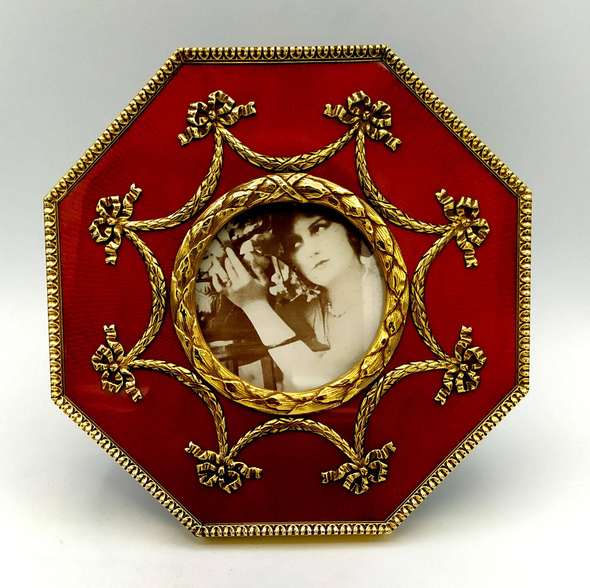 Large octagonal table frame for round photos diameter cm. 7, in 925/1000 sterling silver gold plated with translucent fired enamel on sunburst guilloche, with Napoleon III French Empire style borders and ornaments. External cm. 17 x 17. Weight gr.