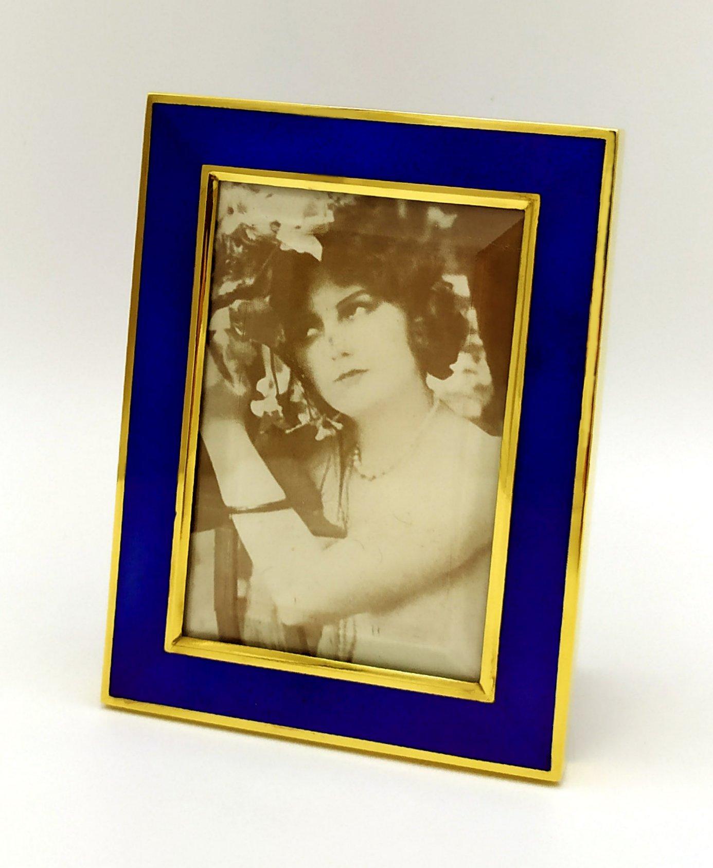 Rectangular photo frame in 9251000 sterling silver gold-plated with translucent fired enamel on guilloché. Modern contemporary style. Ground glass. Blue alcantara panel. External dimensions cm. 9 x 12, internal cm. 6 x 9. Weight gr. 96. Designed by