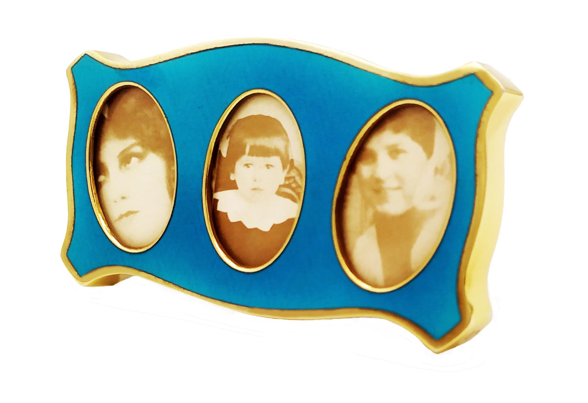 Shaped frame for 3 photographs in 925/1000 sterling silver gold plated with translucent fired enamels on guillochè. Modern Baroque style. Blue velvet panel. External measures cm. 5.5 x 10.2 with 3 oval interiors cm. 2.3 x 3.5. Weight gr. 52.