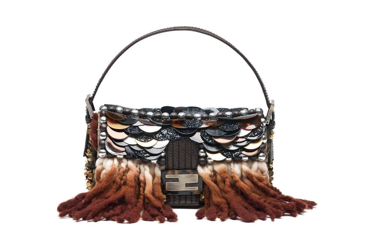 Unique Piece!
Fendi embroidered Baguette with metal sequins, wool fringes and mirrored leather circular disks, PVC, glitter and crystal appliqués.
Adjustable leather shoulder strap
Burnished brass side metal detailing with engraved Fendi logo
Dark