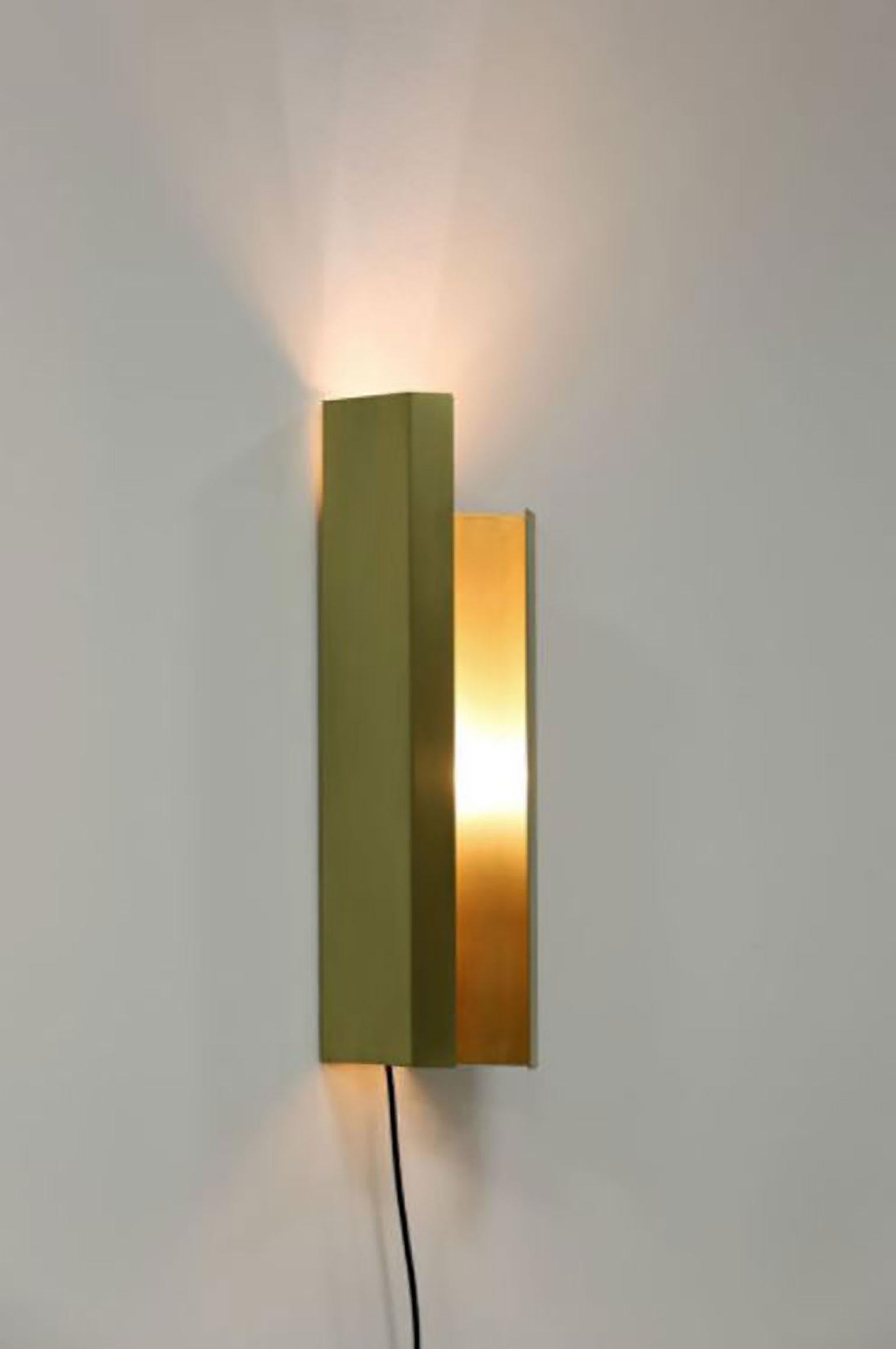 Piega wall lamp by Aldo Parisotto & Massimo Formenton for Mingardo. Piega is a lighting piece in black steel or raw brass. The wall lamp is the combination of bent metal sheets. Their overlapping produces a sculpted shape that nests an E27 bulb,