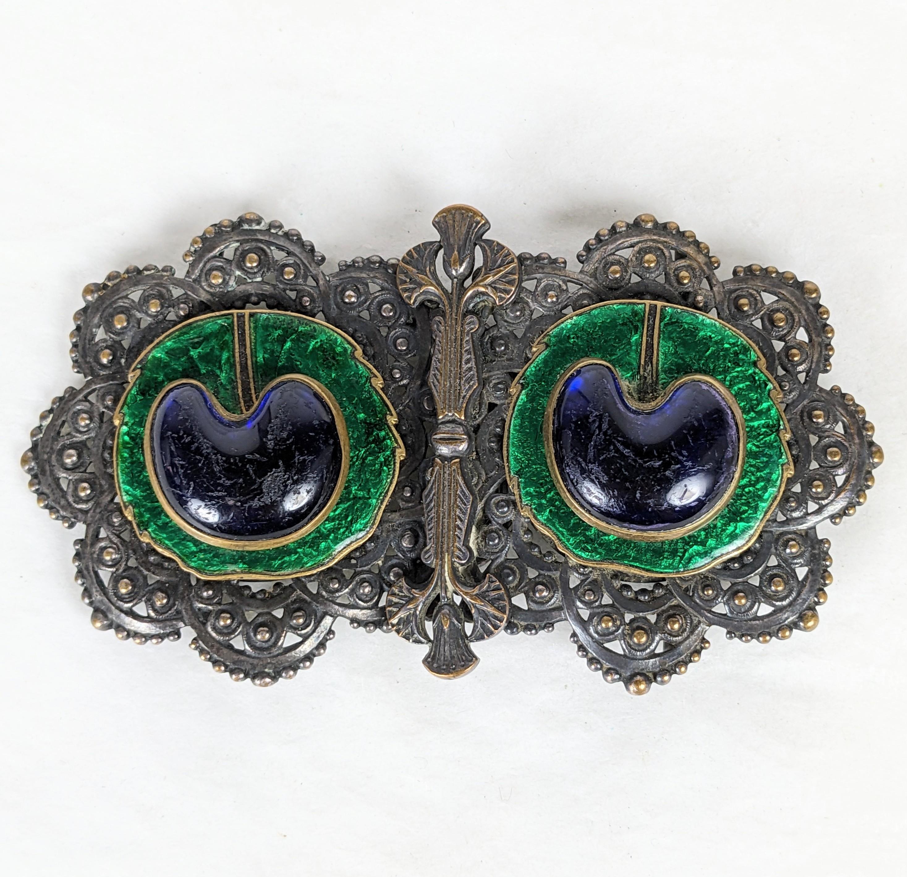 Art Nouveau Piel Freres Peacock Eye Egyptian Revival Buckle from the 1920's France. Silverplated brass with Egyptian Lotus motifs set with sapphire poured glass peacock eyes on green enamel. Signed PF. 1920's France. 3.5