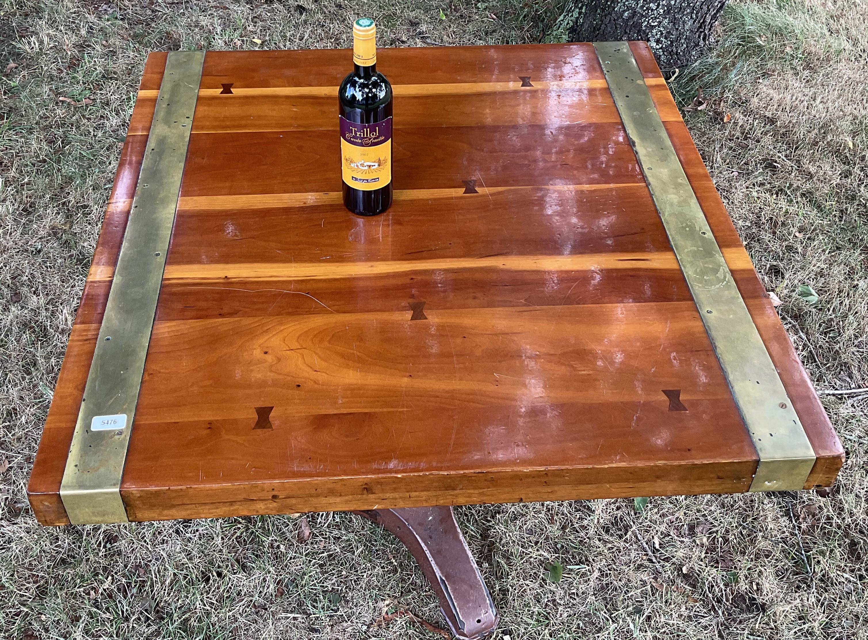 Brass bound dining table from Antnony's Pier 4 Restaurant in Boston. Thick laminated wood top with bow tie fasteners. Pedestal base from the 