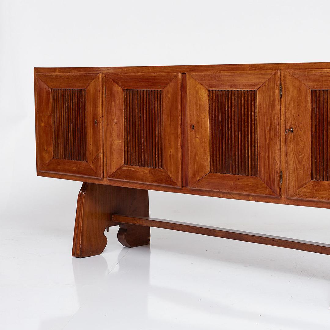 This 1950’s Italian credenza by Pier Luigi Colli embodies both elegance and exceptional craftsmanship. The front of this piece comprises four cabinet doors featuring a fluted wood detail. Another noteworthy aspect of this piece lies in its robust,