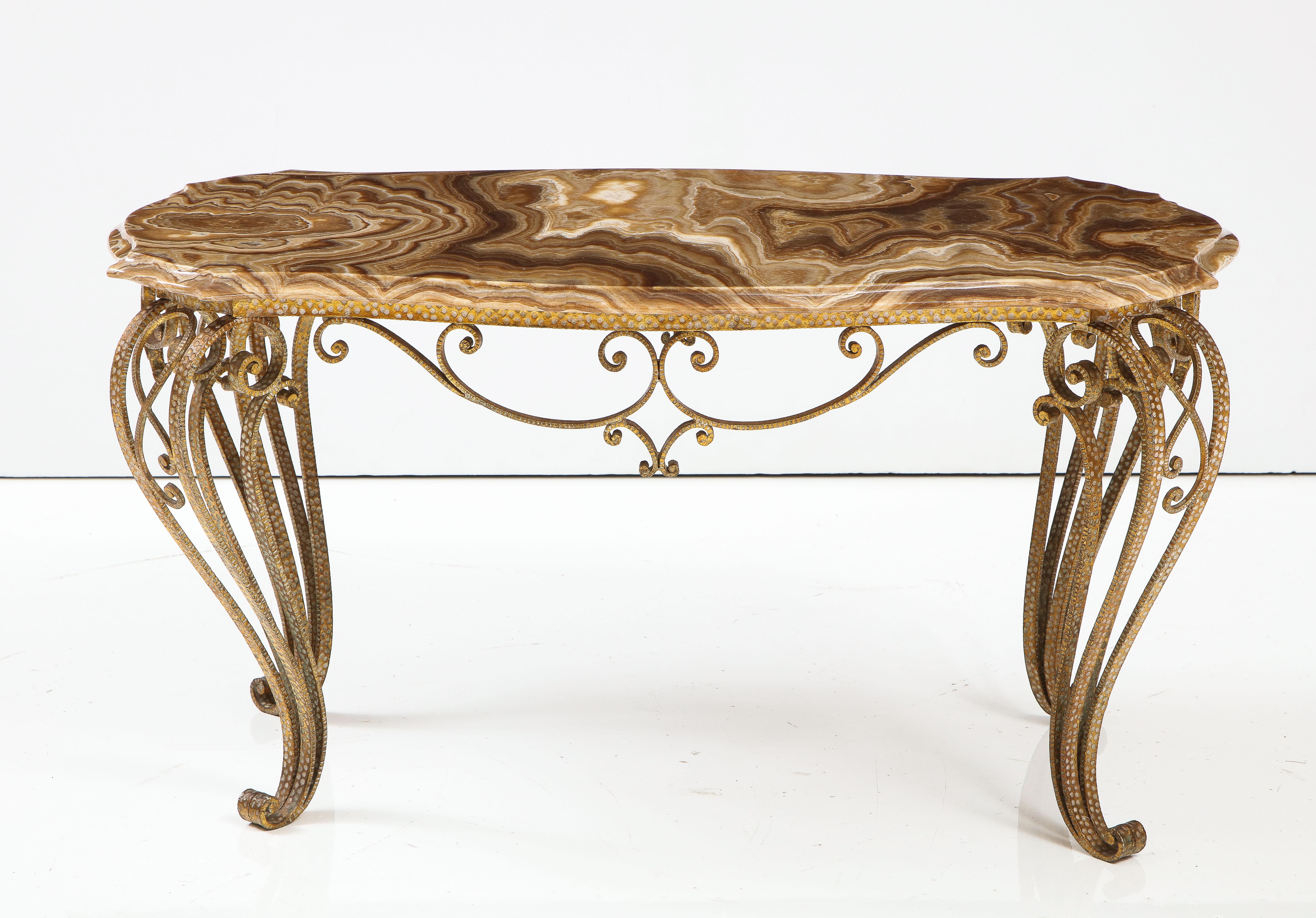 A fanciful gilded iron coffee table with intricately hammered details, the apron with foliate and scroll motif and elegantly appointed cabriole legs, support the shapely exquisite hand beveled agate top. A superb piece designed by Pier Luigi Colli,