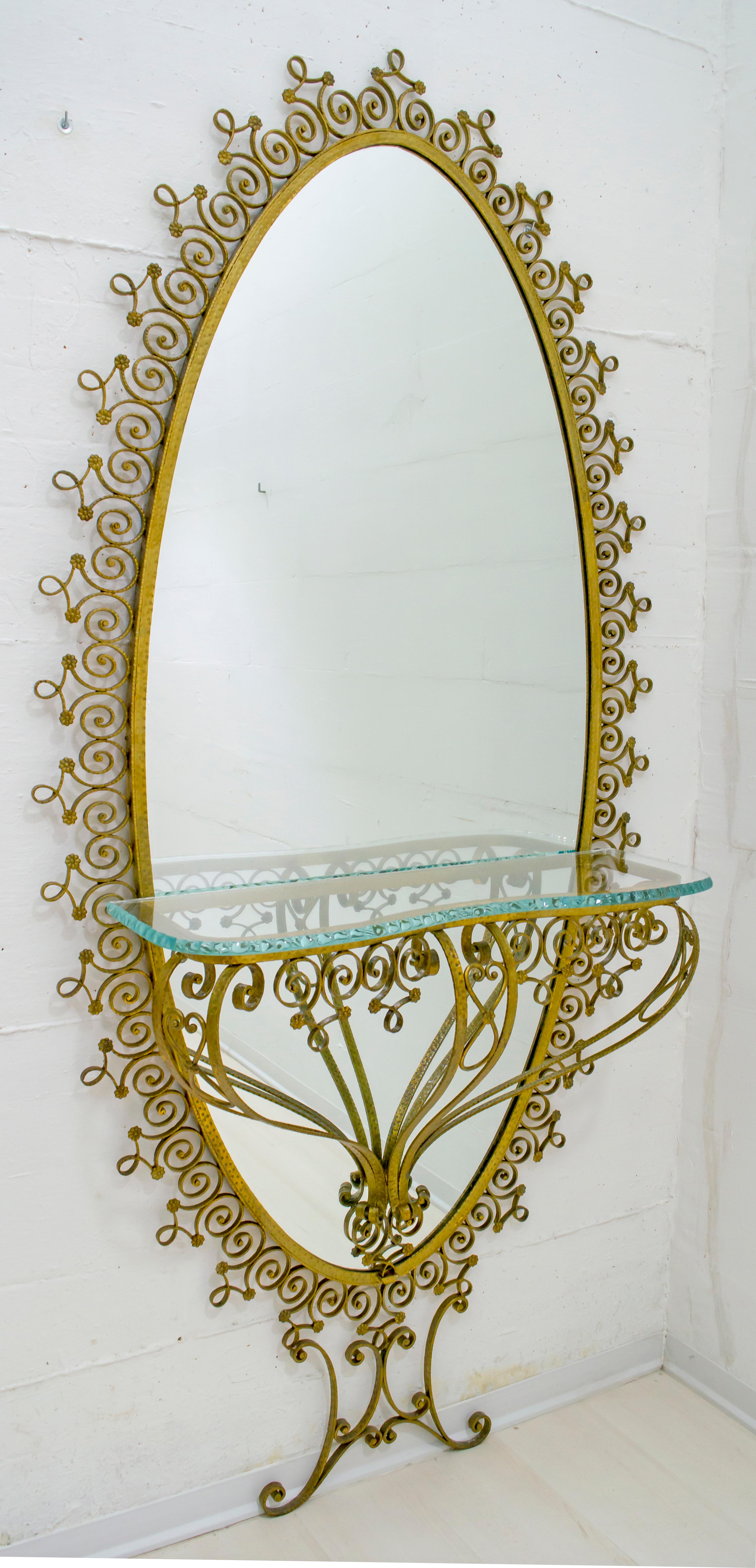 This large oval mirror with a mounted console has a gilded wrought iron frame and was designed by Pier Luigi Colli. It can be installed without the console, mirror and console separately
the top is in hand chiselled crystal

The company Colli was