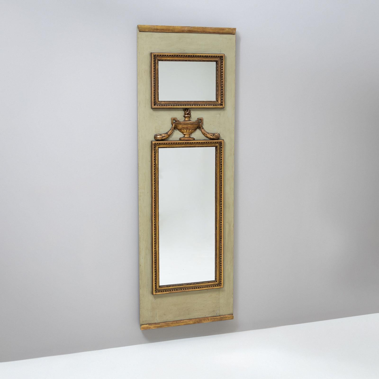 Un élégant miroir français de la fin du XVIIIe siècle. Le cadre en bois patiné vert présente des moulures profilées et des ornements de frise décoratifs. Au centre, un motif d'urne flammée souligne le style classique. Au-dessus du miroir principal