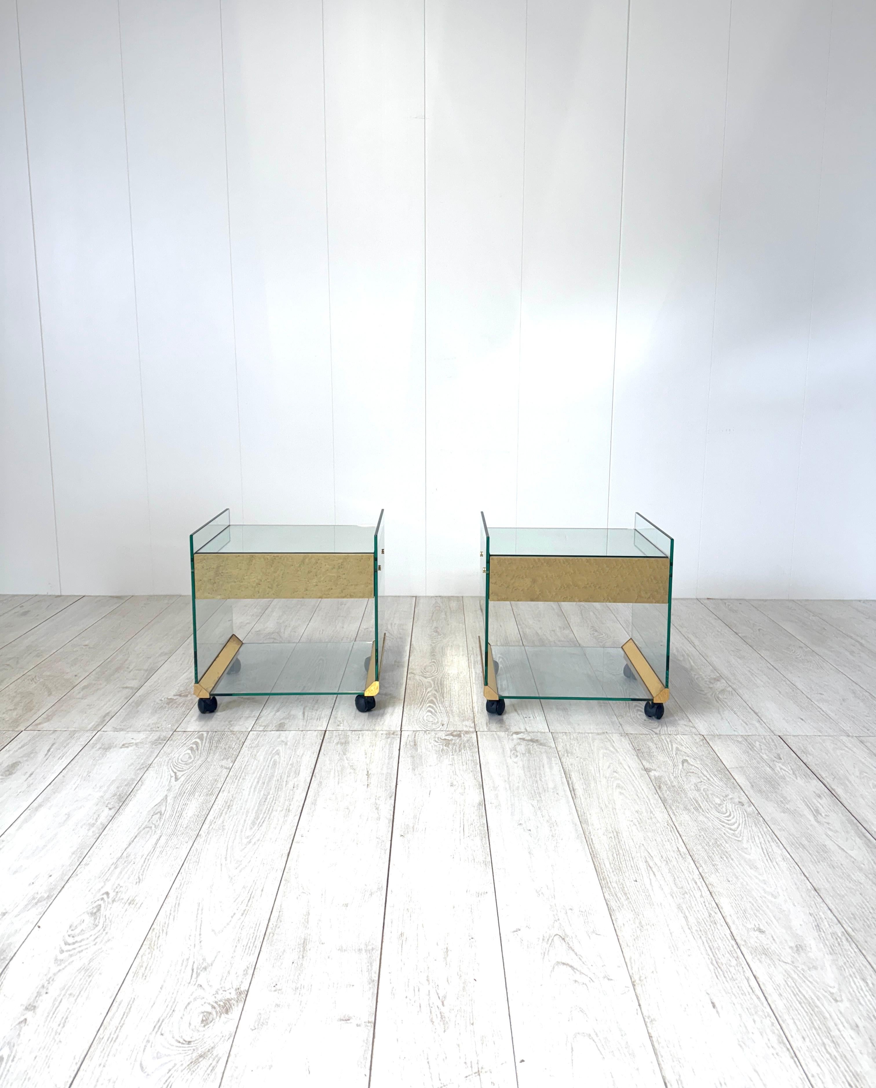 Paire de tables de chevet des années 1970 produites par Gallotti & Radice.
Structure en verre et en verre miroir, détails en laiton. Tiroir central en bois.
Les tables de chevet sont équipées de roulettes pour faciliter leur déplacement

Bon état