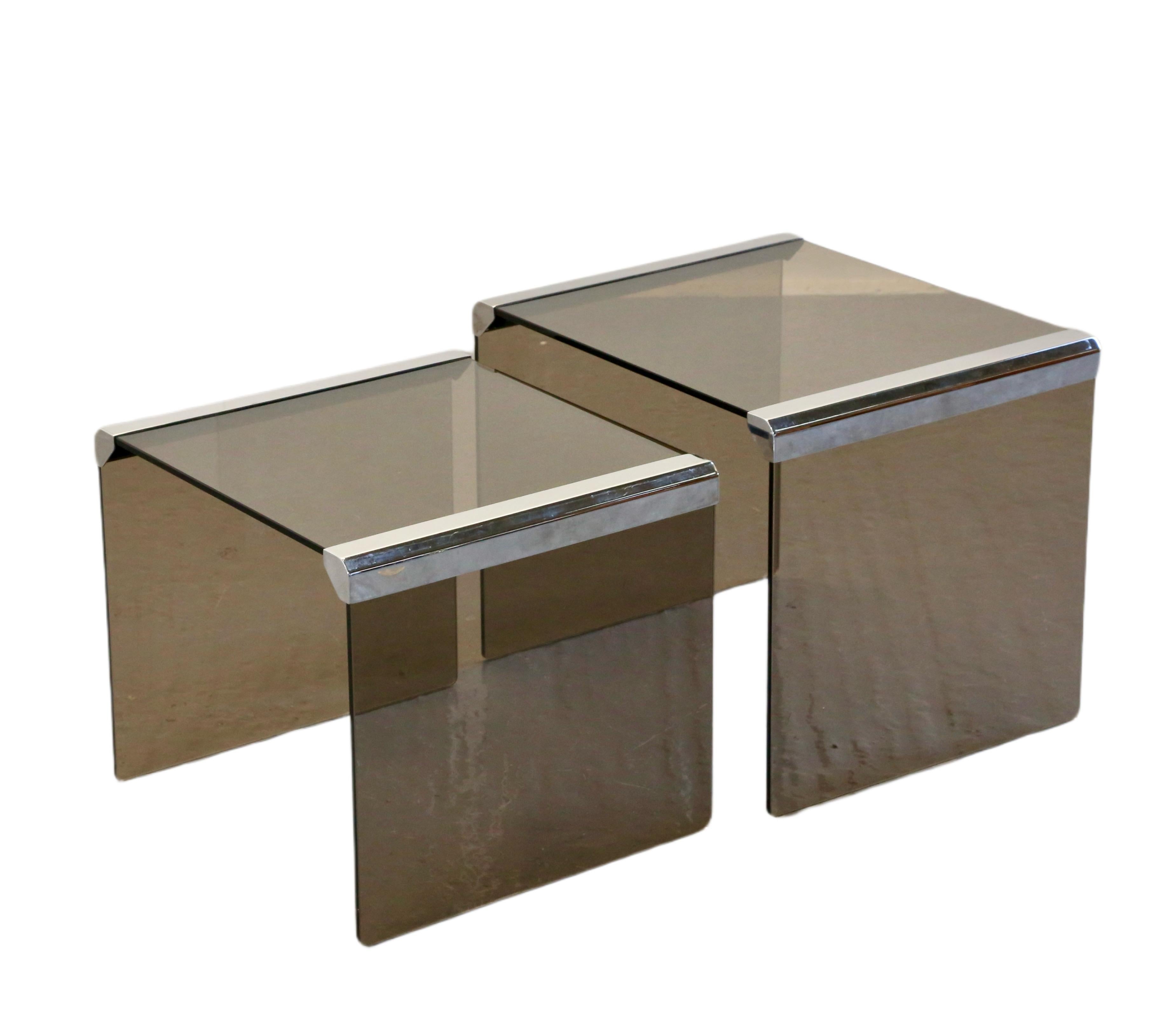 A fabulous set of Italian Mid Century Modern nesting tables, designed by Pierangelo Gallotti, possibly in collaboration with Luigi Massoni, for Gallotti&Radice. The tables feature high quality smoked and toughened glass with chromed steel edges.