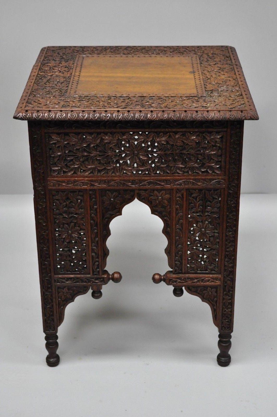 Ornately carved teak wood Moorish/Moroccan accent side table. Item features solid teak wood construction, nicely carved floral and leafy scrollwork, pierce carved base, very unique side table. circa mid-late 20th century. Measurements: 24