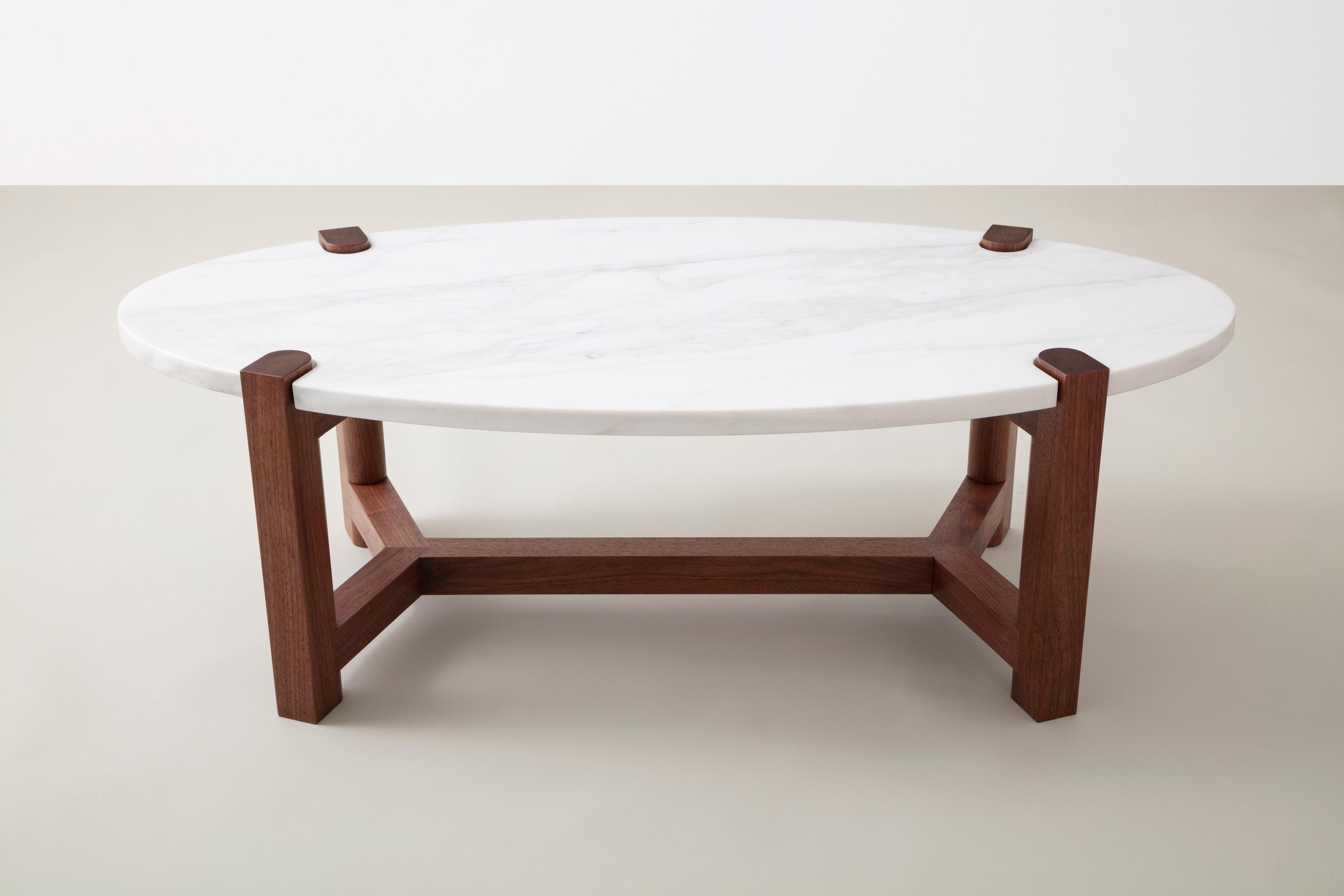 Here details and connections become the focus at the intersection of surface and structure.

Frame shown in American black walnut, also available in cherry, ash, or maple.
Top shown in white marble and also available in custom stone and material