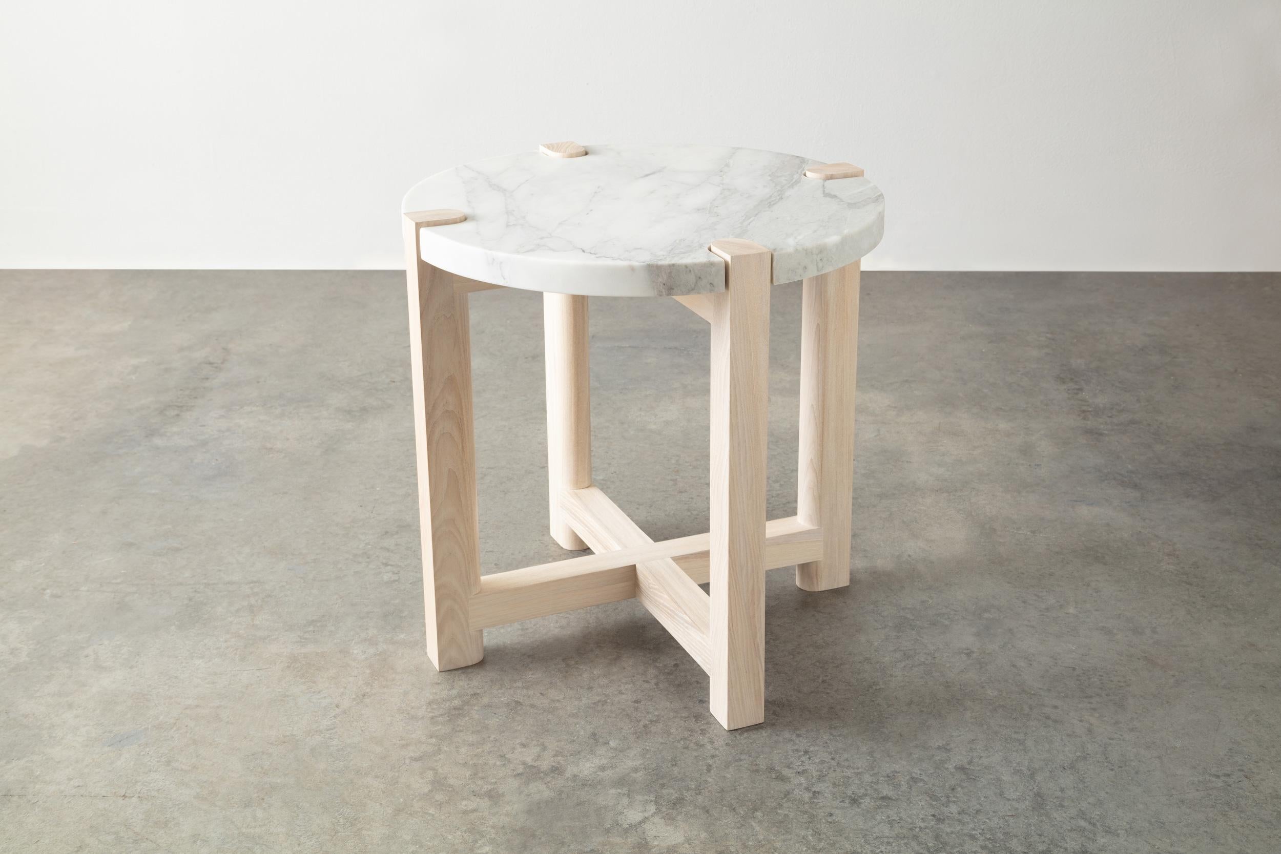 Here the details and connections become the focus at the intersection of surface and structure.

Frame shown in maple and available in ash, white oak, and walnut. 
Top shown in white Carrara marble and also available in custom stone and material