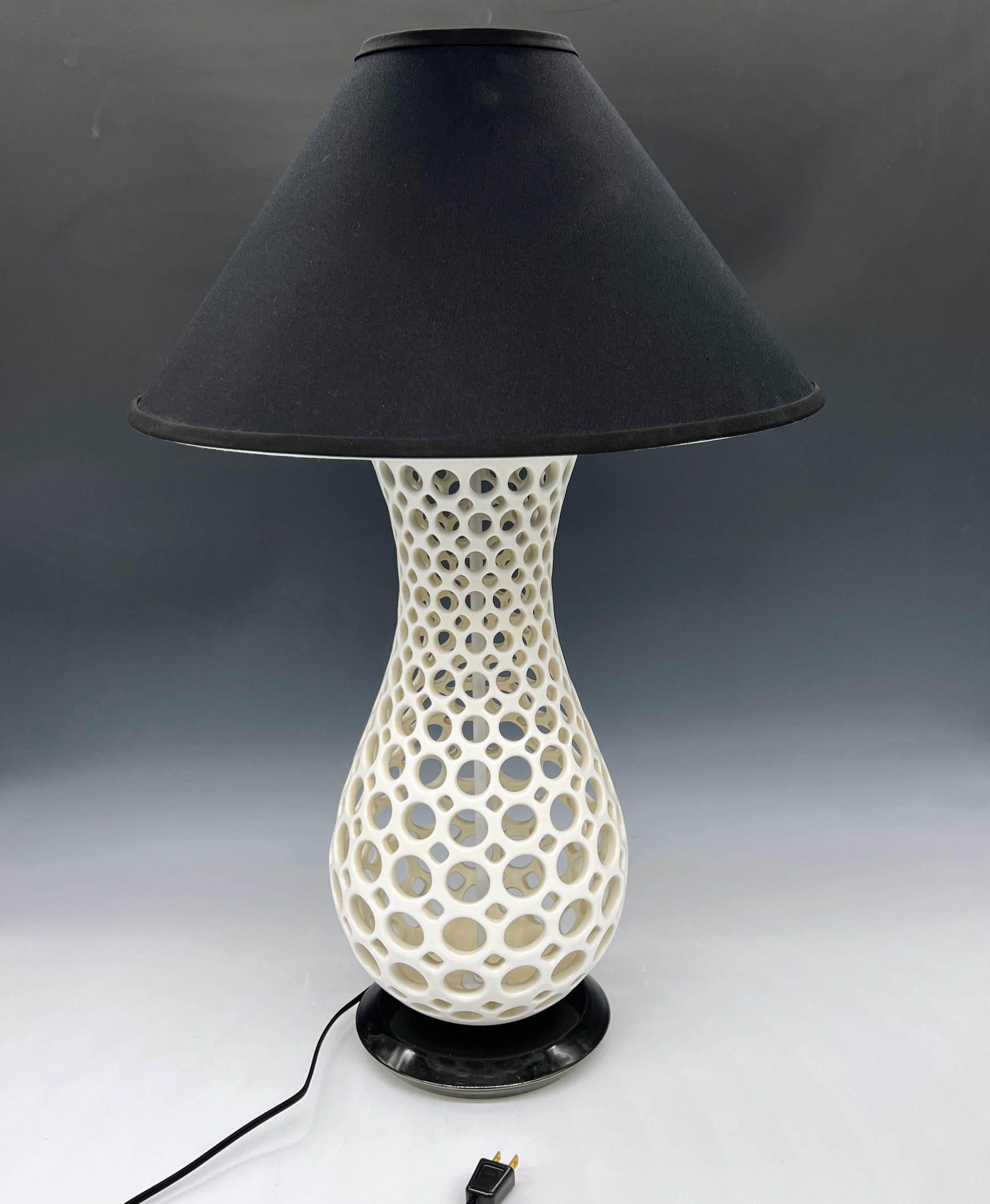 This lamp is wheel thrown and hand pierced with a white satin glaze.
The base is wheel thrown ceramic with a glassy black glaze
Black cord and switch.
Can be used with any wattage bulb.