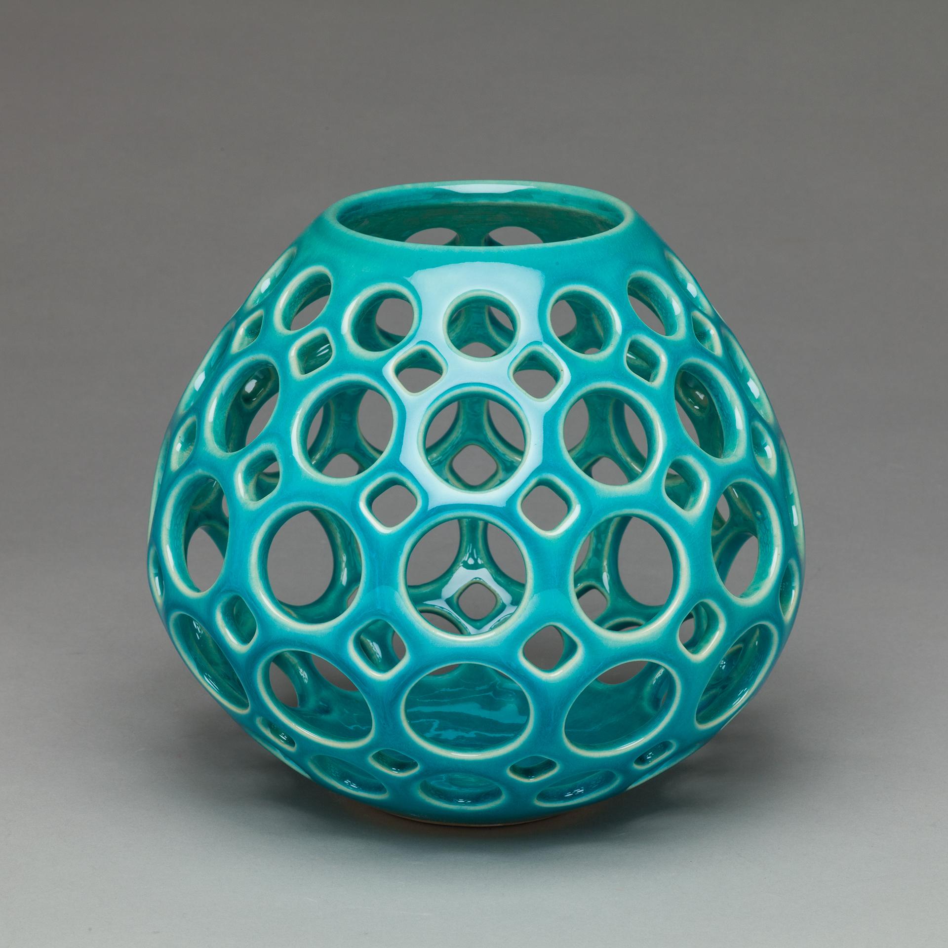 Wheel thrown, hand pierced ceramic tabletop sculpture/ vessel. This piece provides the perfect pop of color to any room. It can stand alone as an art piece, or with a candle, it can illuminate a room or outdoor space creating a light show of playful