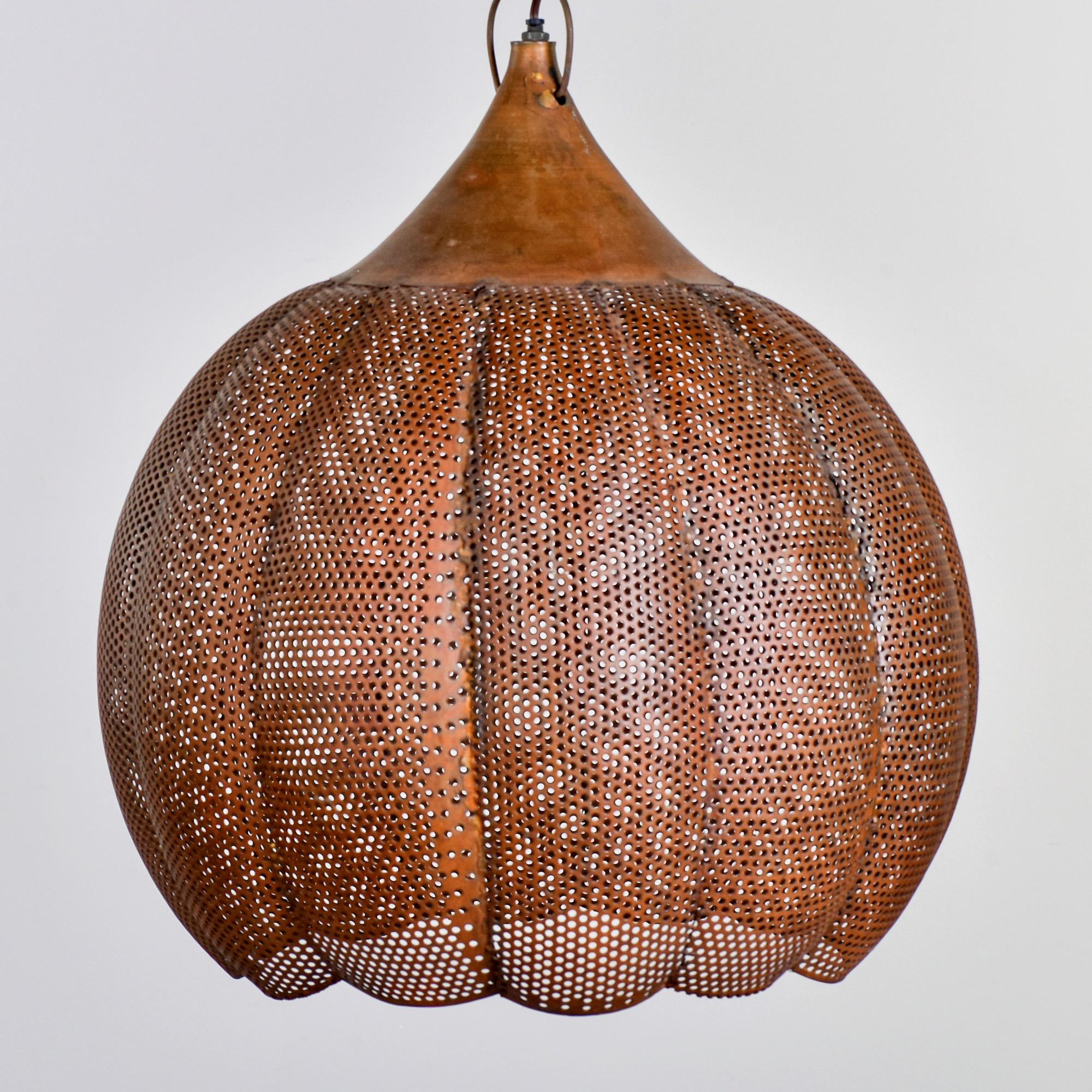 Hanging pendant made of pierced copper in a gourd-like form, circa 1990s. Fixture has one standard sized socket. Found in England. Unknown maker. Wiring has been updated for US electrical standards.