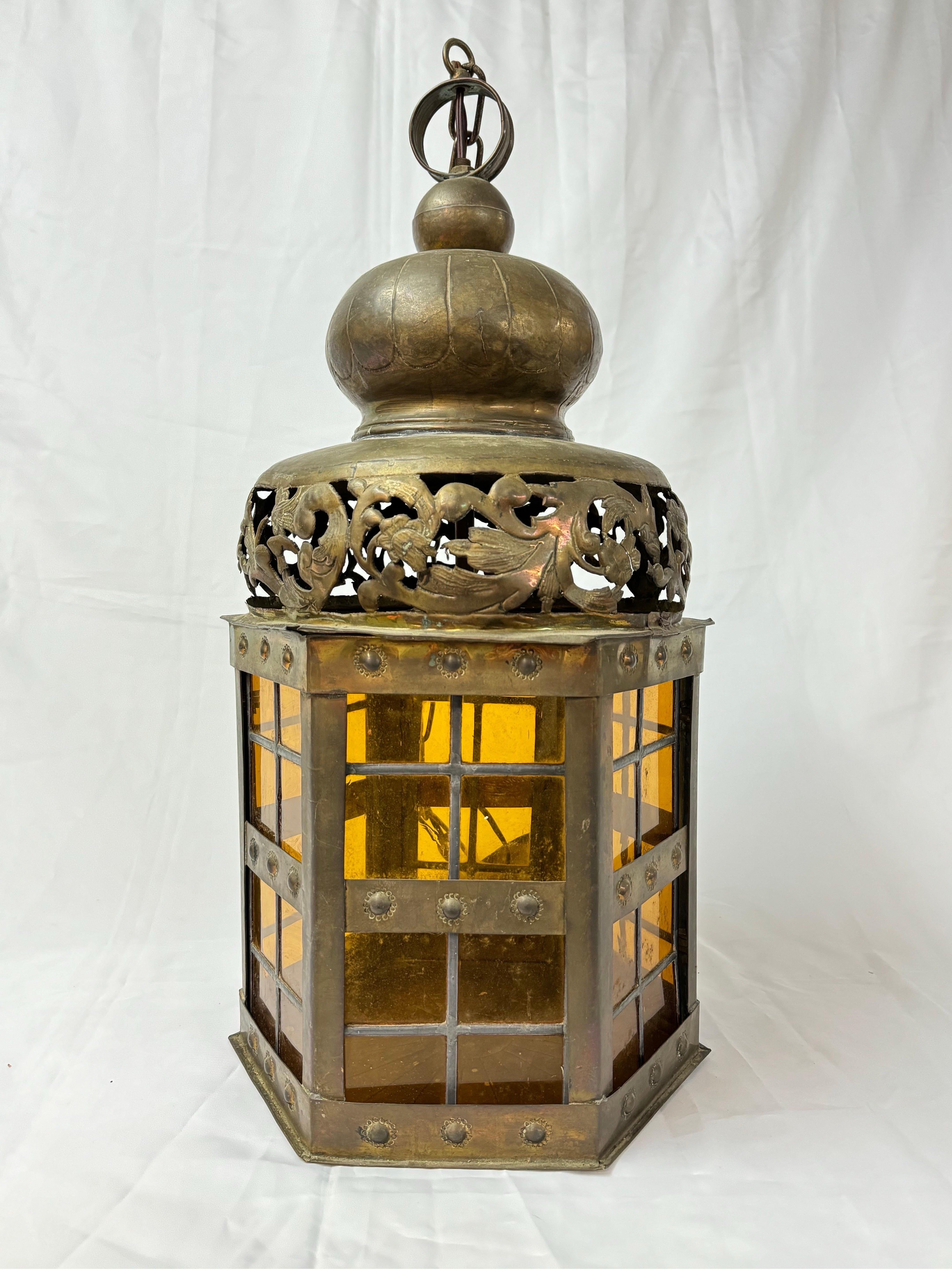 Pierced Moroccan Brass Lantern Style Chandelier. Golden yellow leaded glass windows adorn this beauty. Pierced decorations surround the bulbous top. Stamped designs decorate the exterior brass. Perfect example of unique and romantic lighting.
This