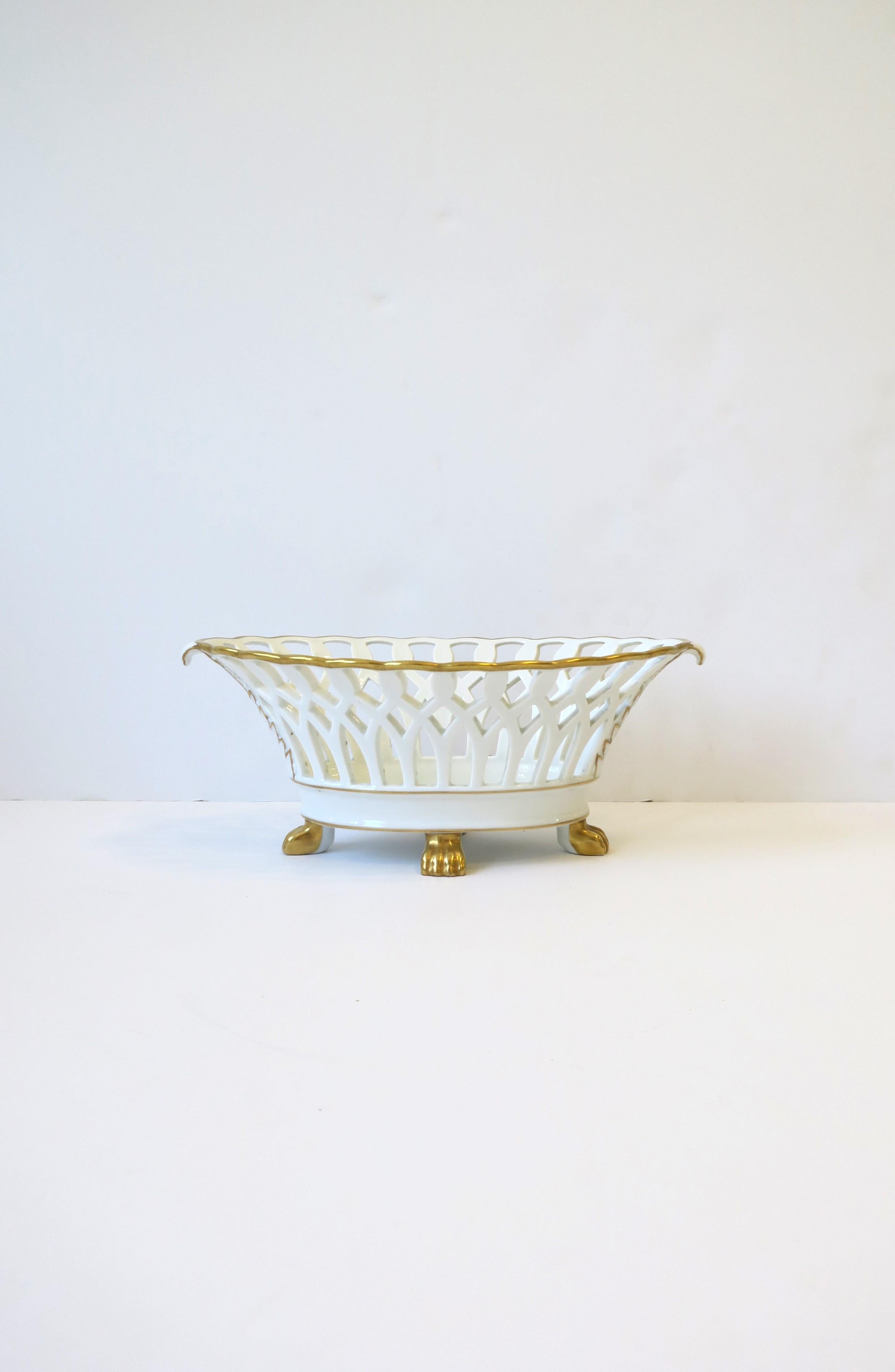 A beautiful oblong white and gold pierced 'Paris Porcelain' style porcelain compote basket bowl with lion paw feet in the Regency / Empire style, circa 20th century, Portugal. This porcelain basket is beautifully made, oblong/marque shape with gold