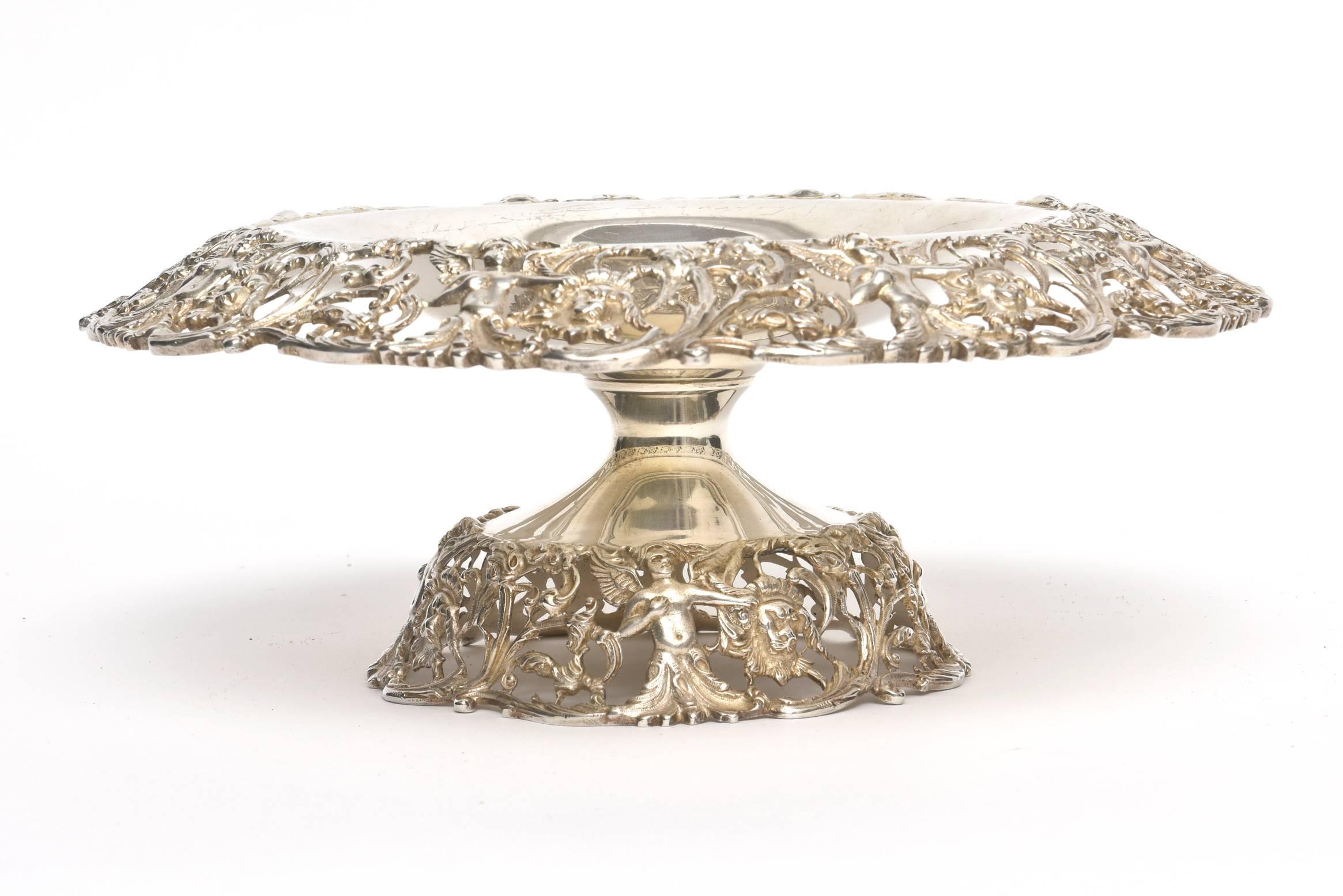 Mid 20th Century American sterling silver reticulated compote by Durham Silver Co. featuring a pierced edge and foot with a winged cherub and lion design.  This ornate compote features an everted top section with pierced putto busts and lion masques
