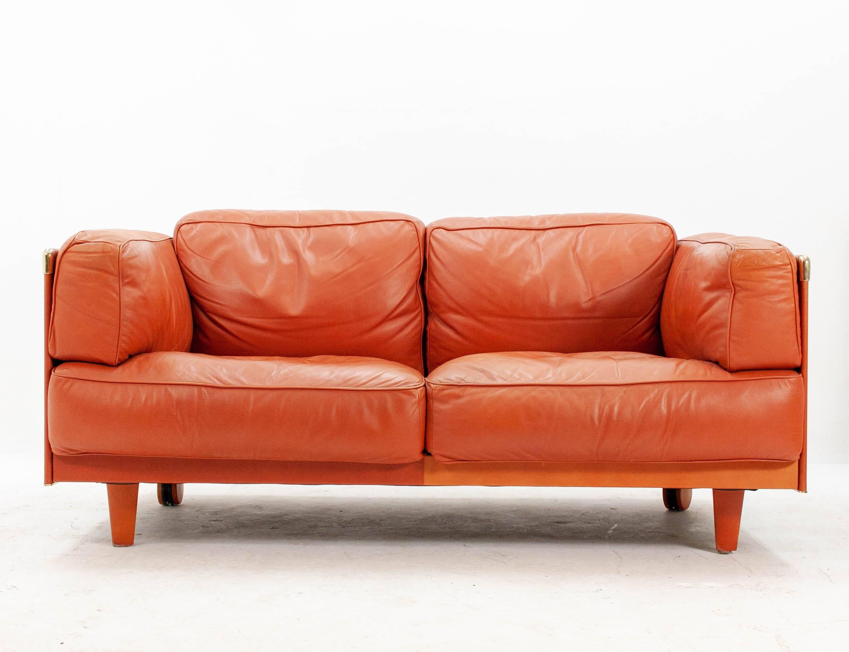 Beautiful handcrafted two-seat sofa in a rich, buttery soft orange leather. This is the two-seat version of the Poltrona Frau 'Twice' model designed by Pierluigi Cerra and built in the late 1990s.