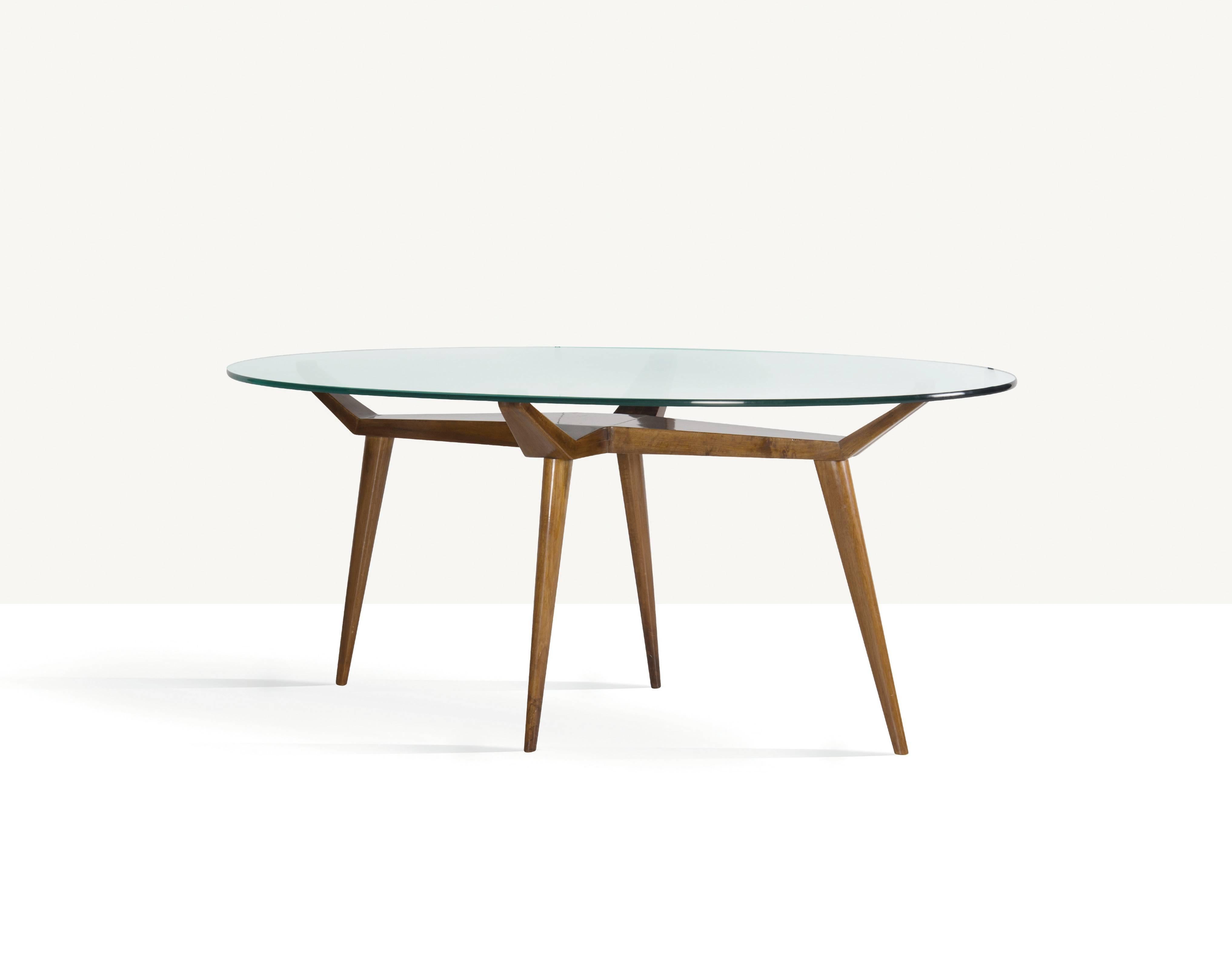 A rare, significant and elegant biomorphic dining table attributed to pioneering Italian midcentury designer Pierluigi Giordani, a contemporary of Ico Parisi and Gio Ponti.  With a large oval glass top resting on four points of a sharply angled,