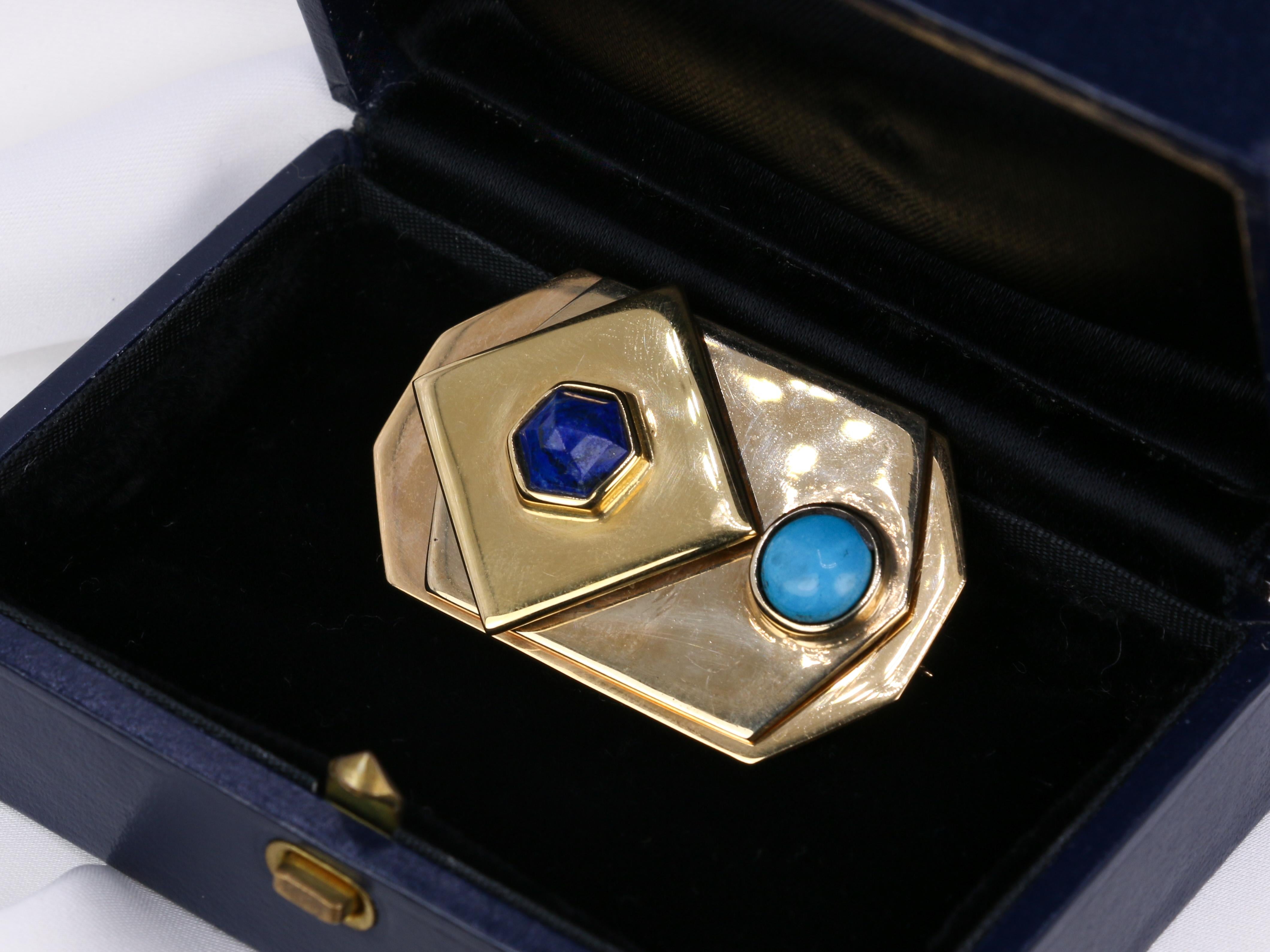 Brooch in 18k yellow gold (750°/°°) signed Piero Dorazio (1927-2005) composed of three mobile elements, one octagonal, the second hexagonal set with a turquoise cabochon in closed setting and the last one, square, set with a faceted lapis lazuli