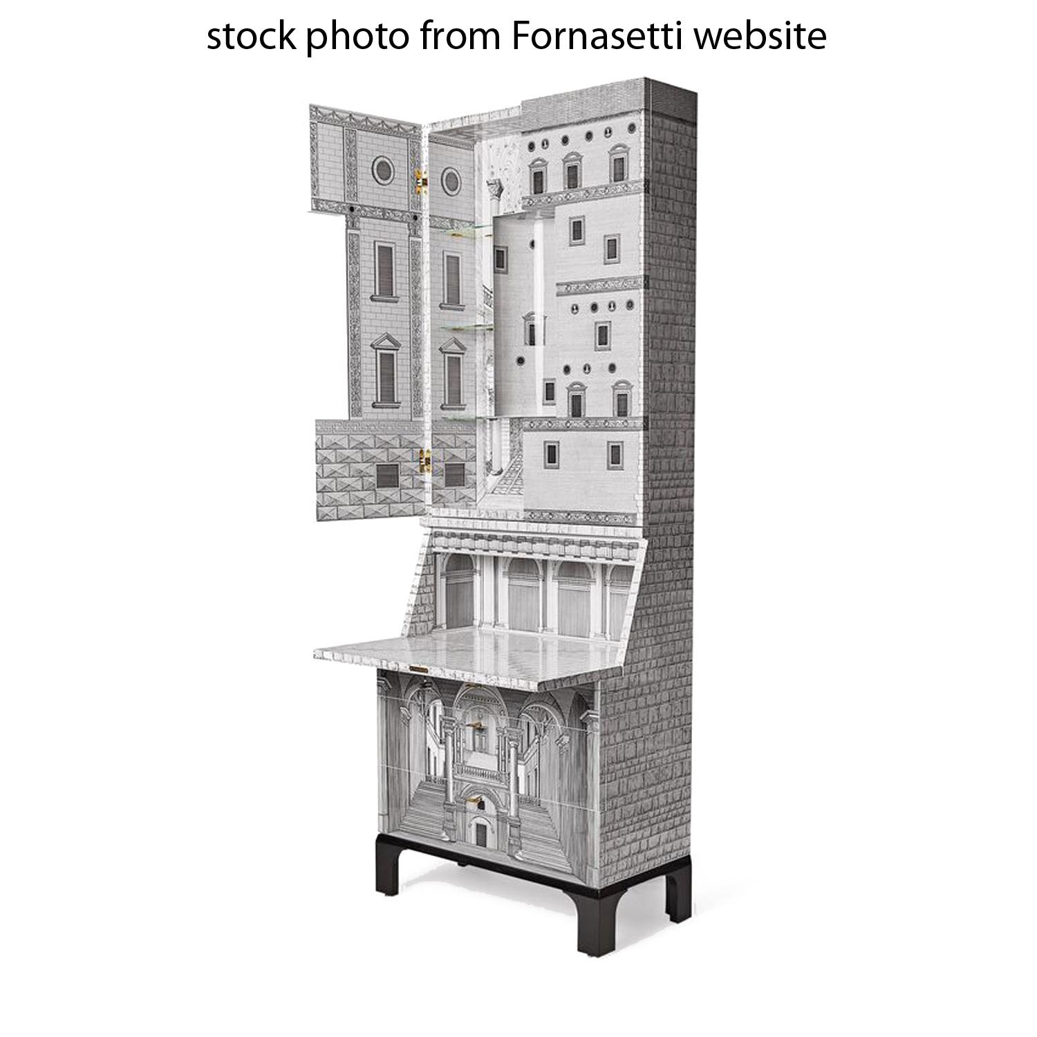 Fornasetti's Architettura Trumeau illuminated cabinet is one of the most desirable examples of Fornasetti-Ponti furniture. A stunning hybrid of a drop-front desk, bar and credenza. Three drawers, double door, and folding desk with (3) brass keys. A