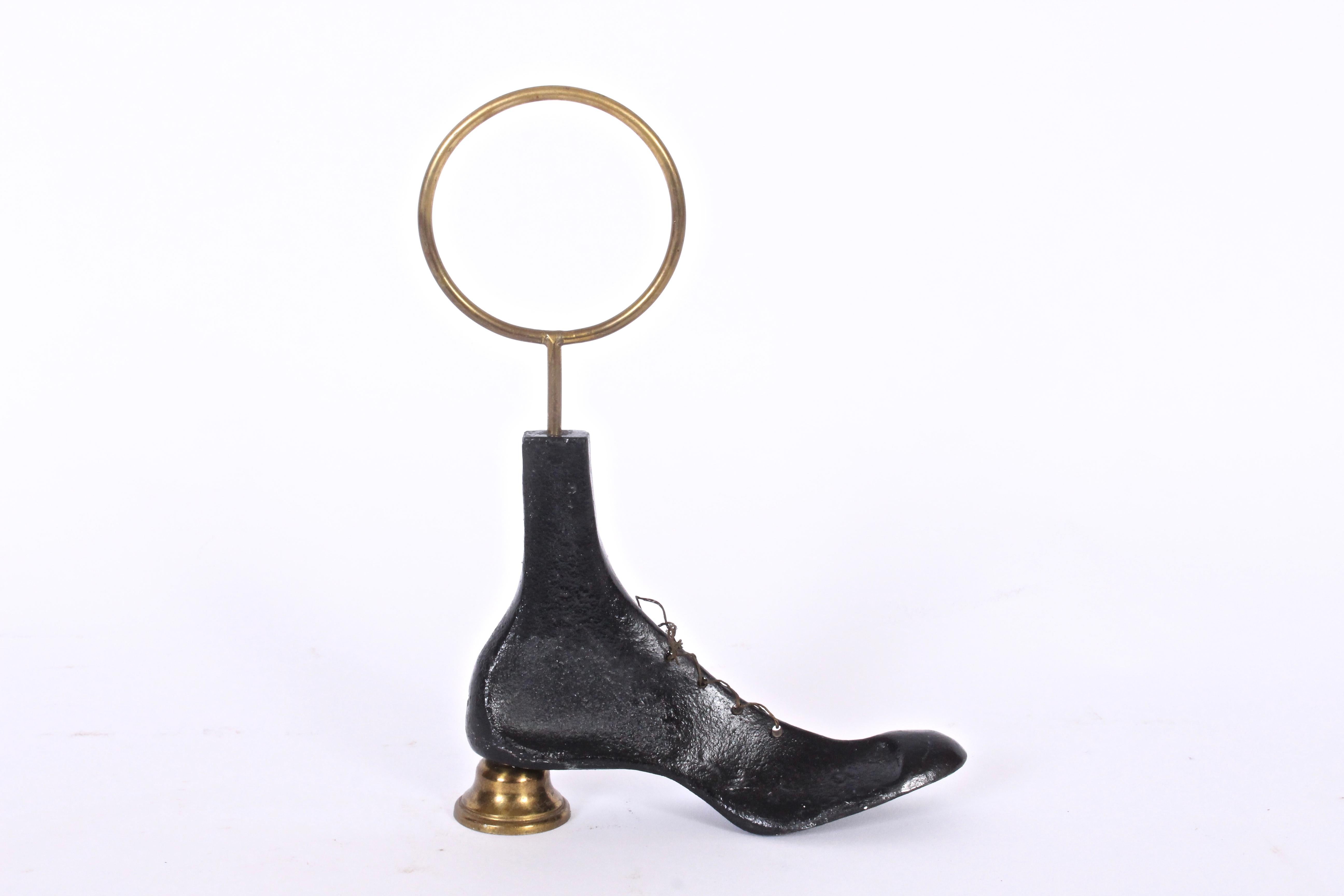 Early Fornasetti Black painted cast iron tied shoe form with Brass heel and finger ring. Detailed with tied string laces. Sculptural. Victorian. Functional. Decorative. Rarity. Boudoir. Bedroom. Dressing room.