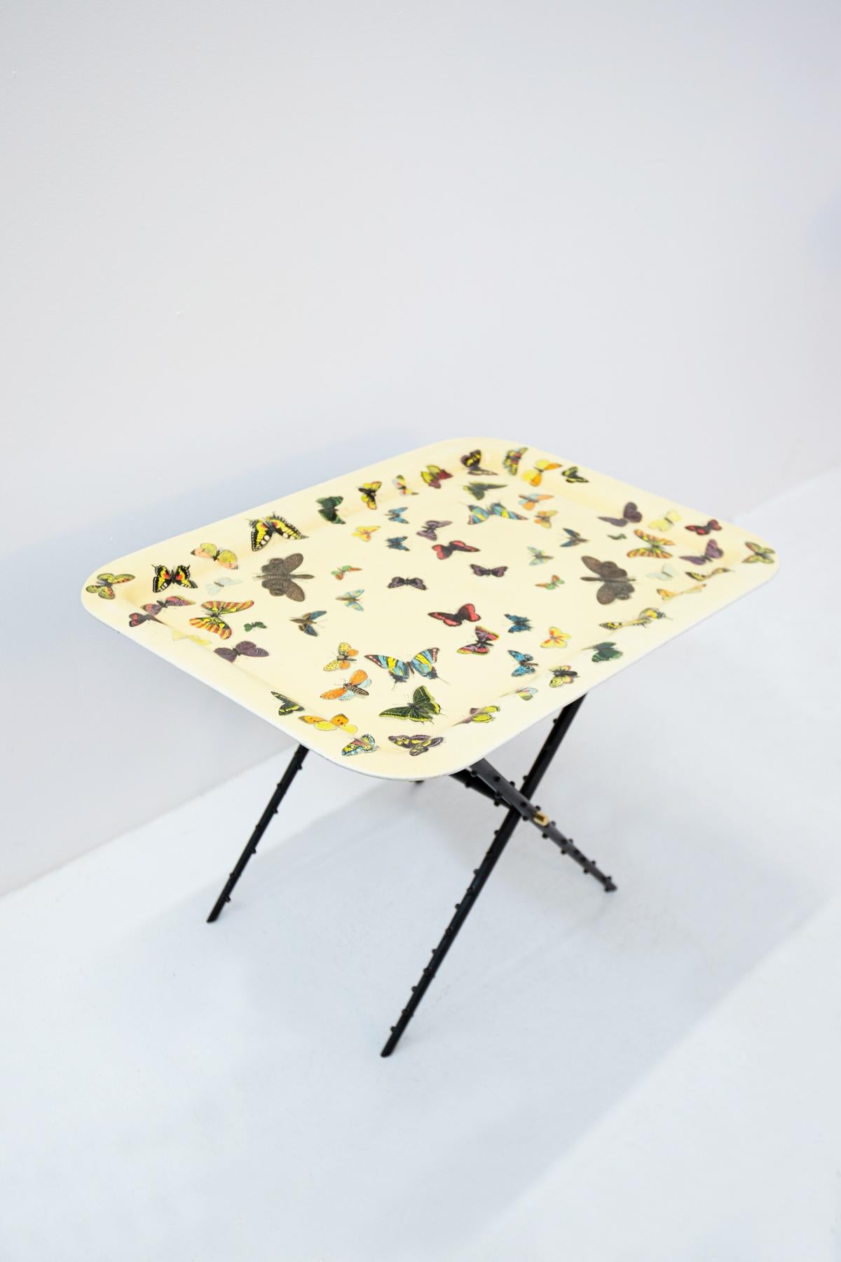 Iconic coffee table by Piero Fornasetti and produced by Atelier Fornasetti in 1950. The coffee table has original label under its top. The table top is made of a silkscreened aluminum tray with a yellow background. Its iconic screen printing